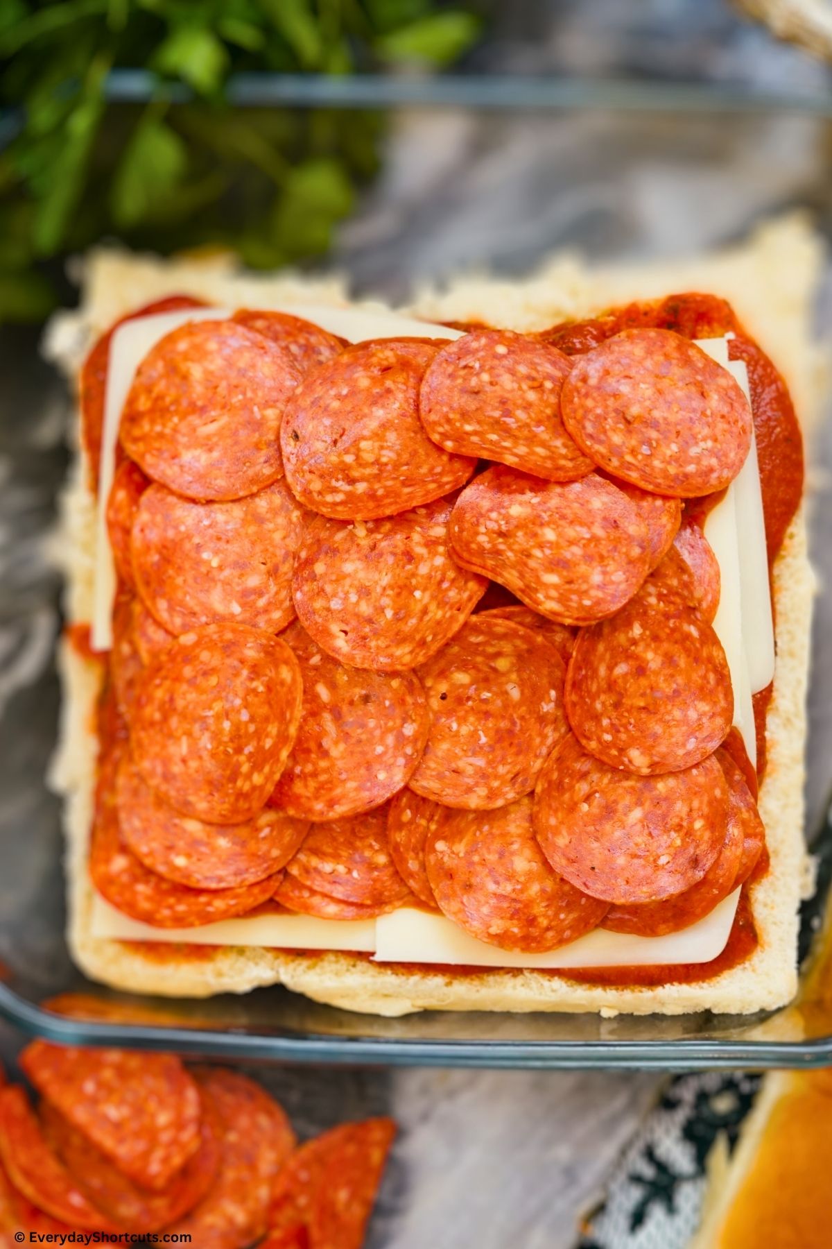 layered Hawaiian rolls with pepperoni cheese and pizza sauce