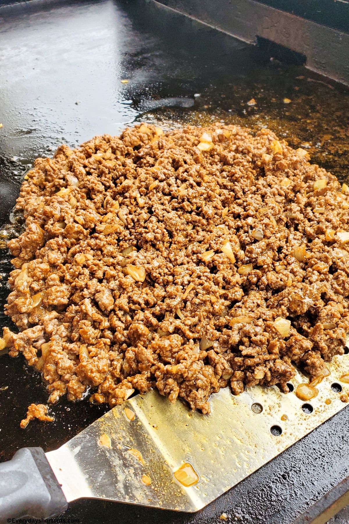 browned ground beef and onions on a griddle