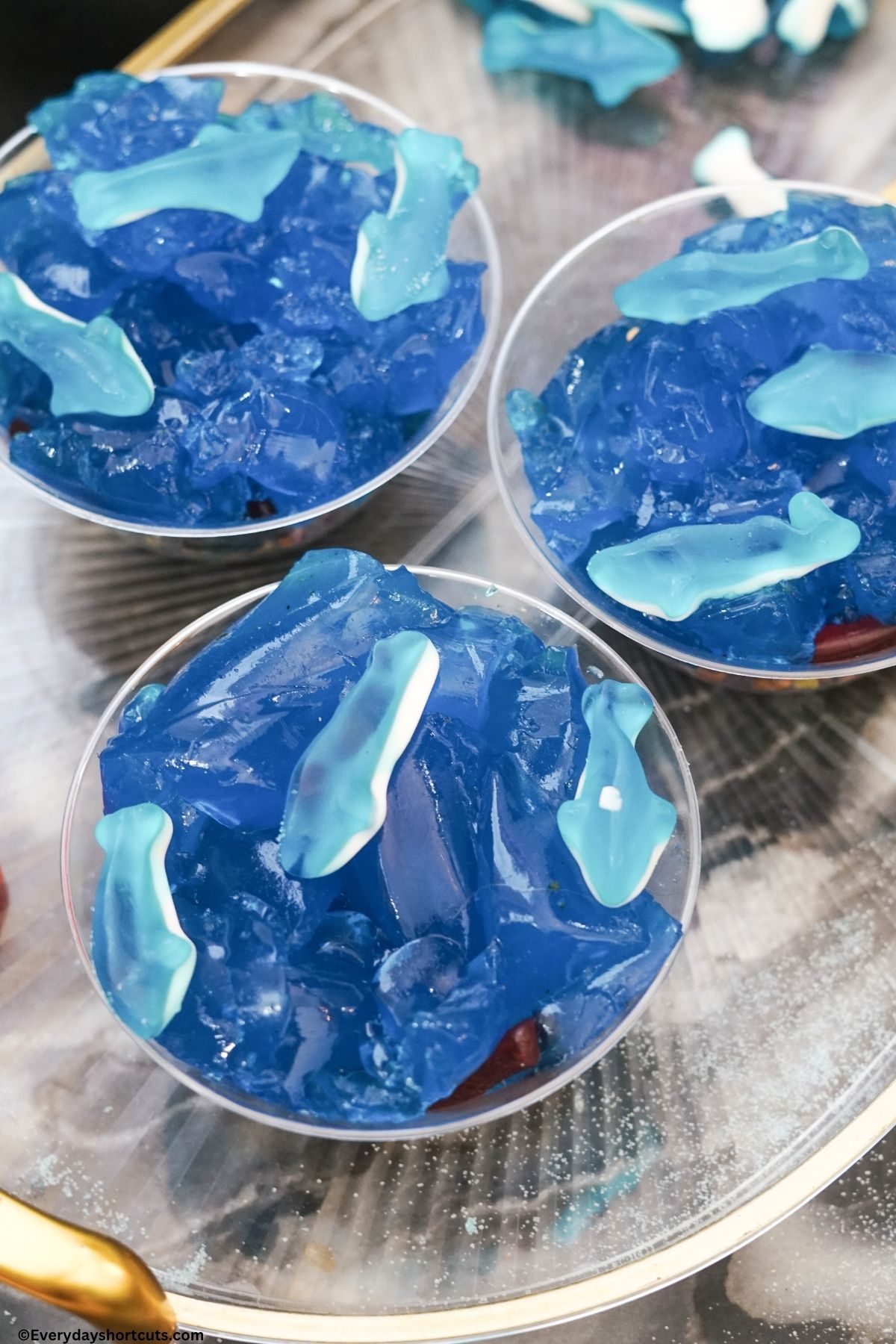 gummy sharks on top of blue gelatin in cups