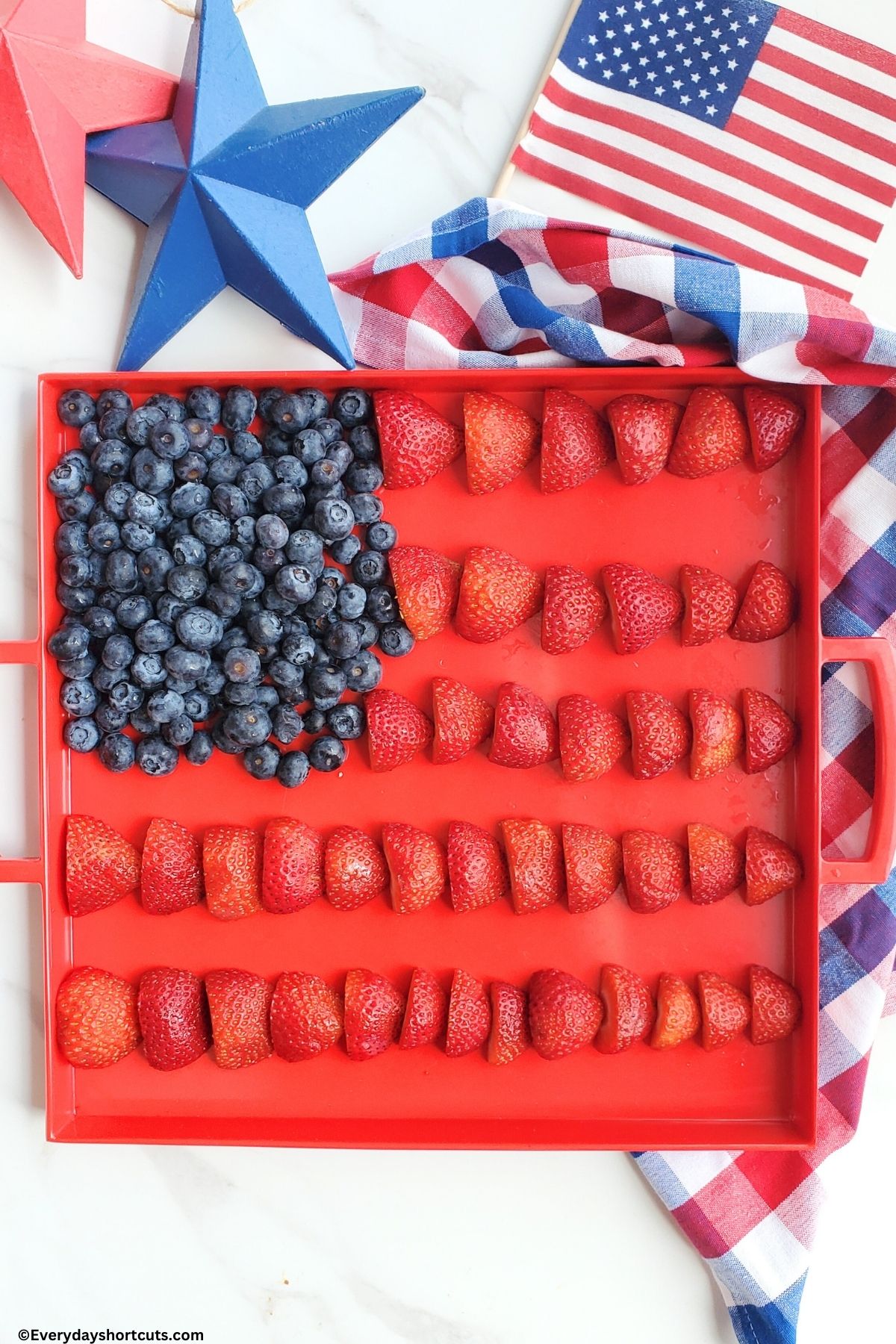 sliced strawberries for flag stripes and blueberries for stars on tray