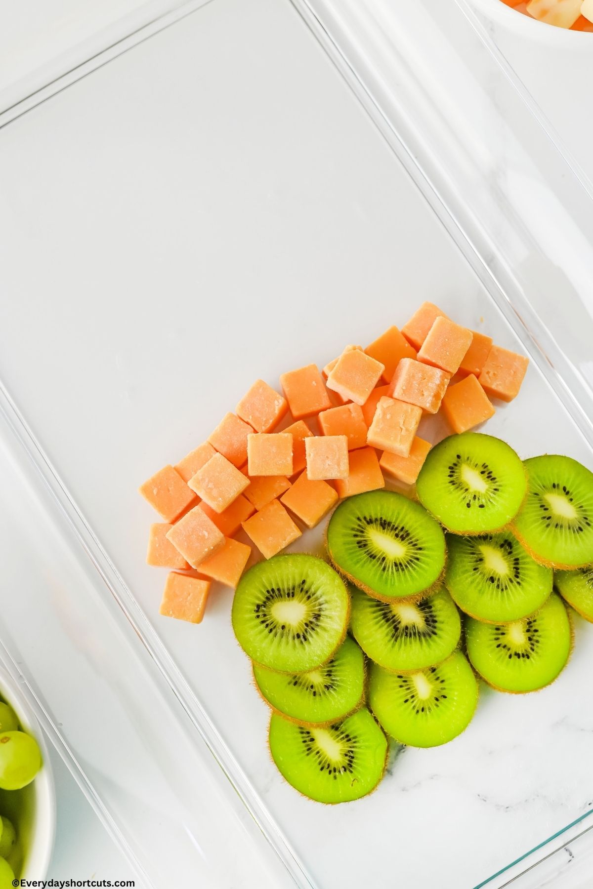 sliced kiwi and cubed cheese on a tray