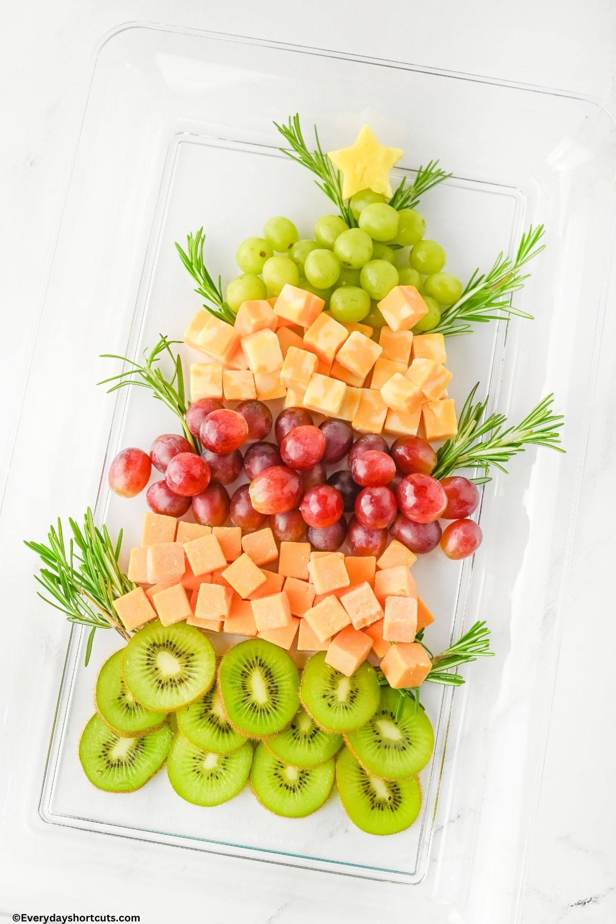 fruits and cheeses in a shape of a Christmas tree