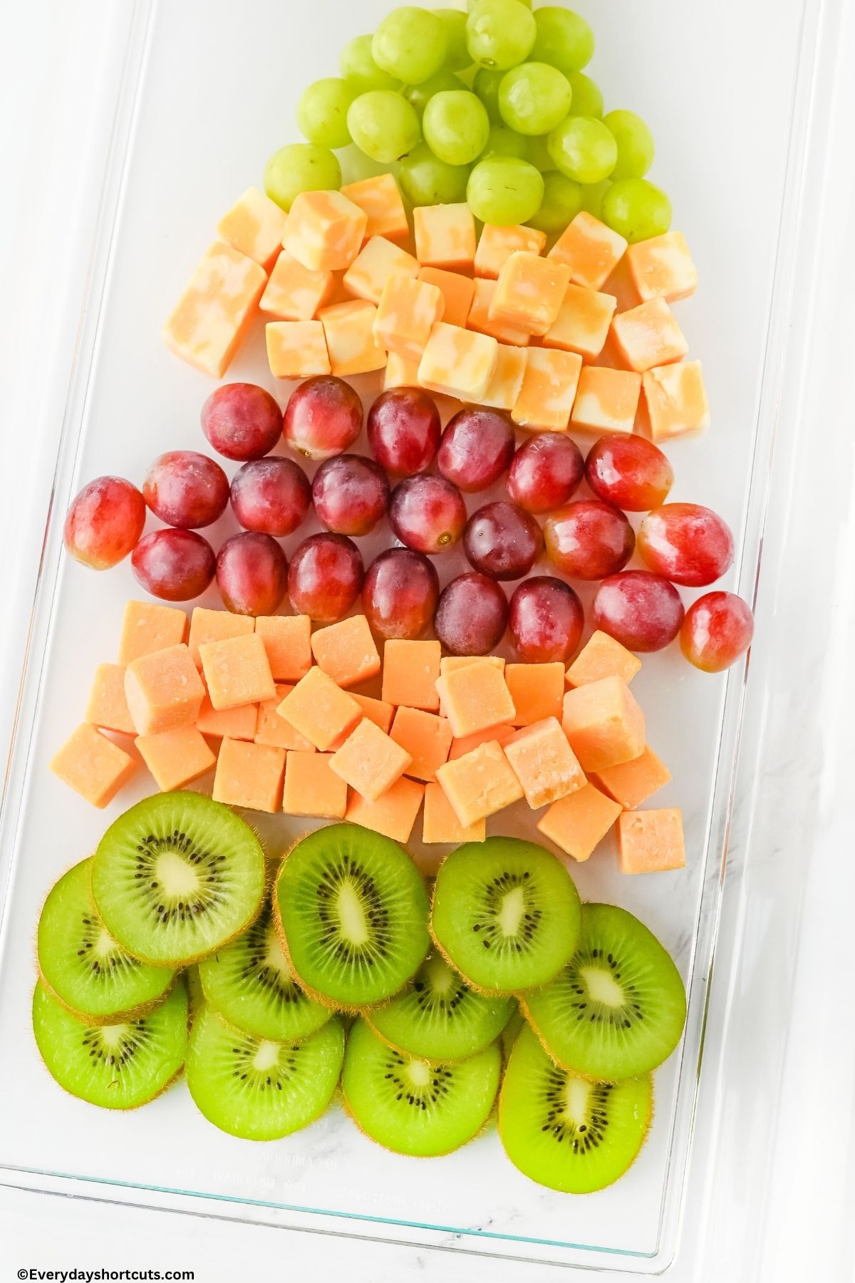 grapes cubed cheeses and kiwi on a platter