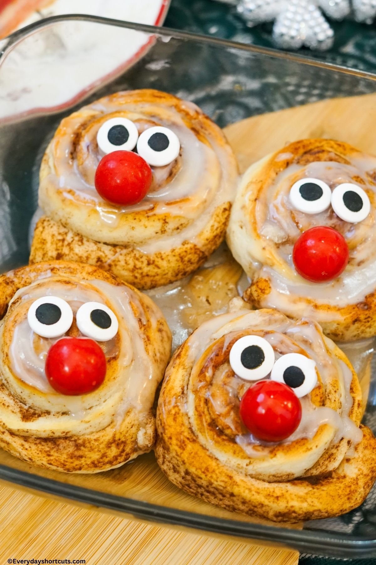 candy eyes and red gumball for nose on top of cinnamon rolls with icing