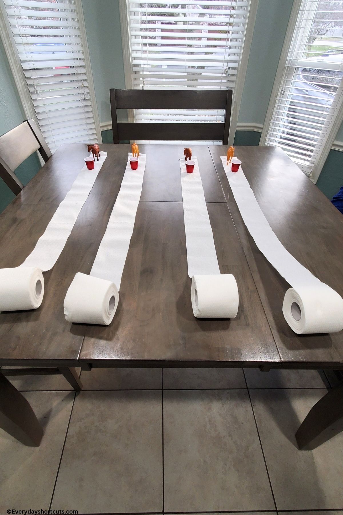 Toilet Paper derby with plastic mini horses shot glasses with water and toilet paper