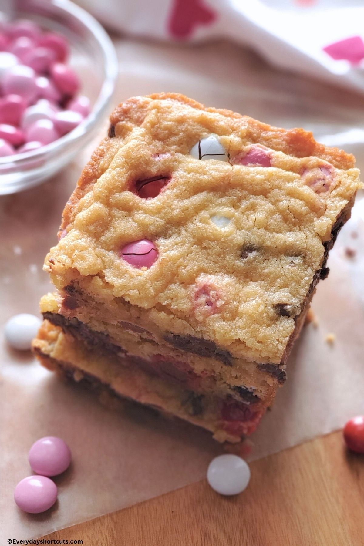 Valentine M&Ms chocolate chip cookie bars stacked on wood cutting board