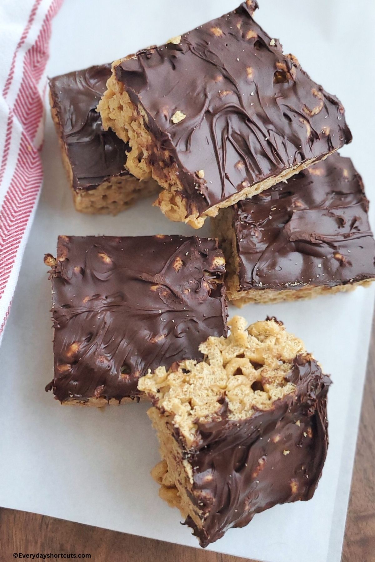 chocolate covered Cheerios bars on a white plate next to a red and white napkin