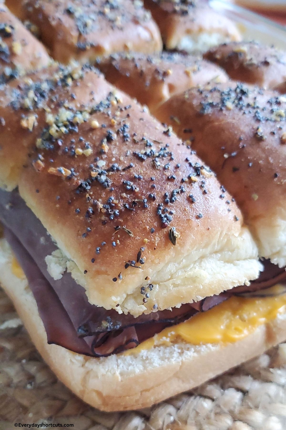 close up of roast beef sliders with cheese in a baking dish