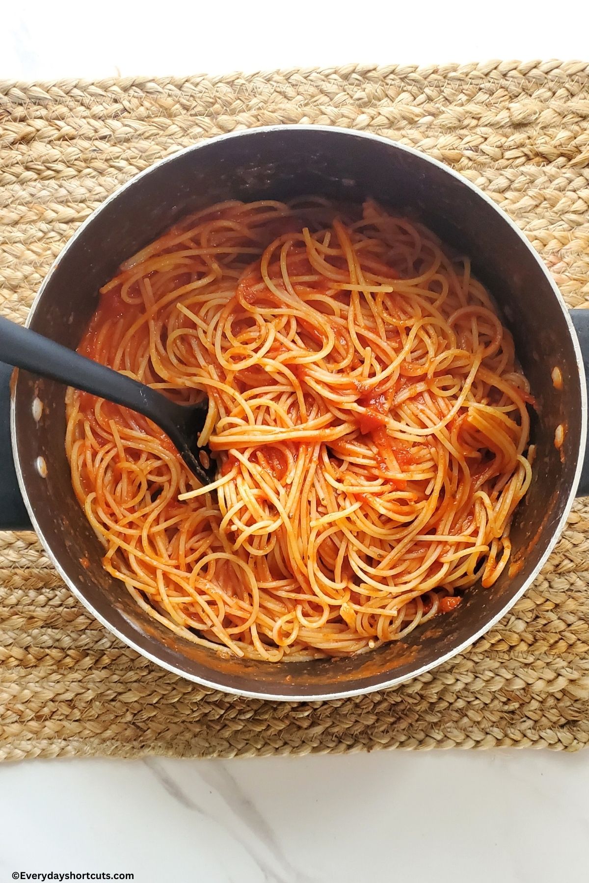 cooked spaghetti noodles in a pot with marinara sauce