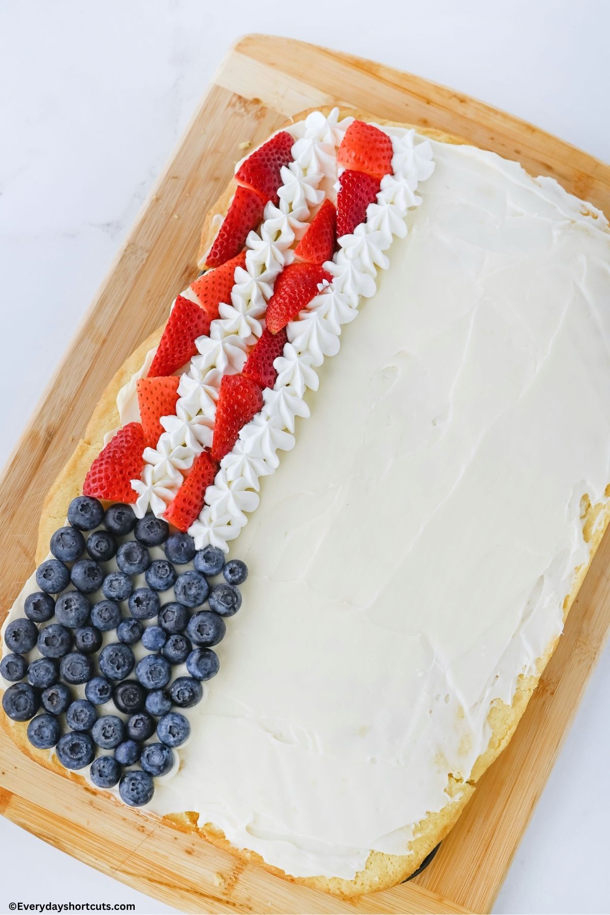 blueberries in the corner and strawberries and cool whip as strips on sugar cookie