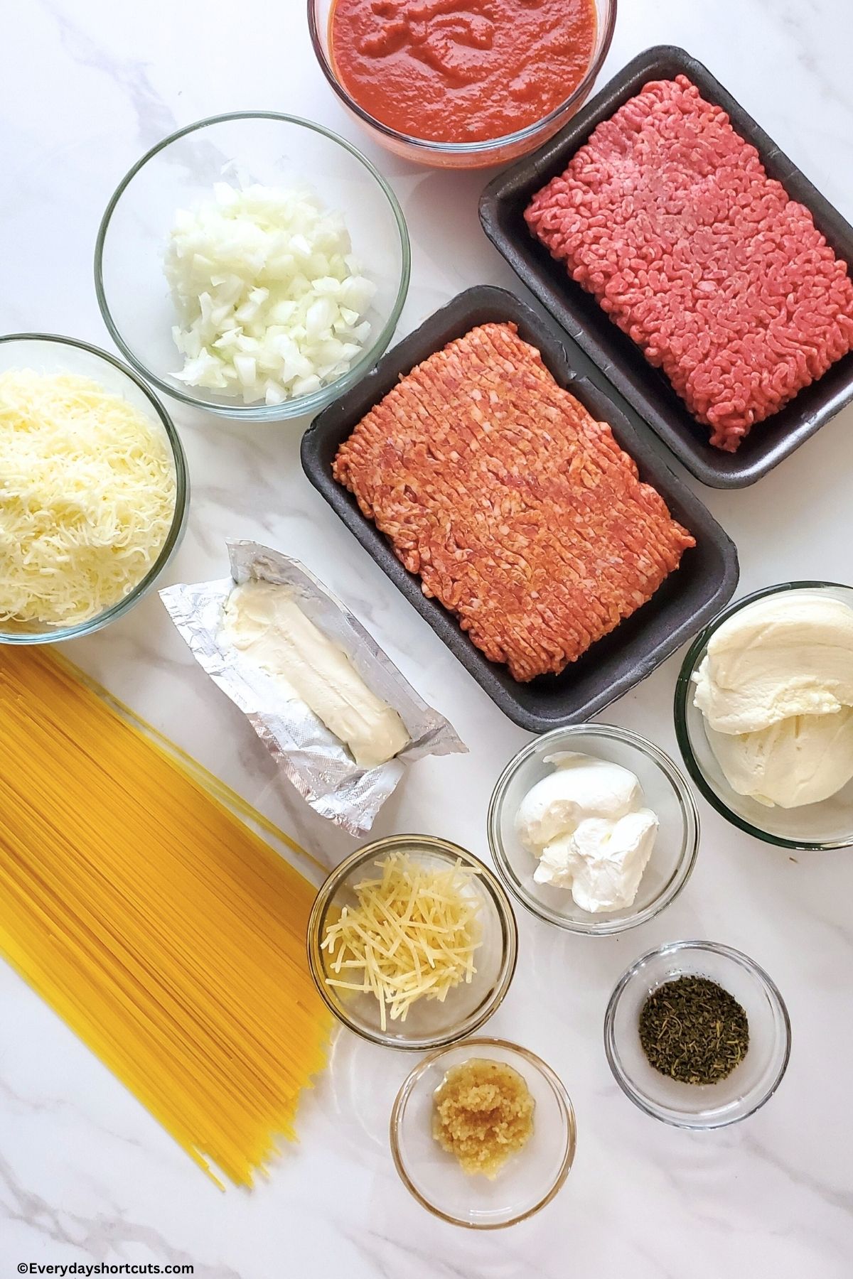 ingredients of ground beef, Italian sausage, ricotta cheese, sour cream, spaghetti noodles, diced onion, cream cheese, Italian seasoning, minced garlic, mozzarella and parmesan cheese