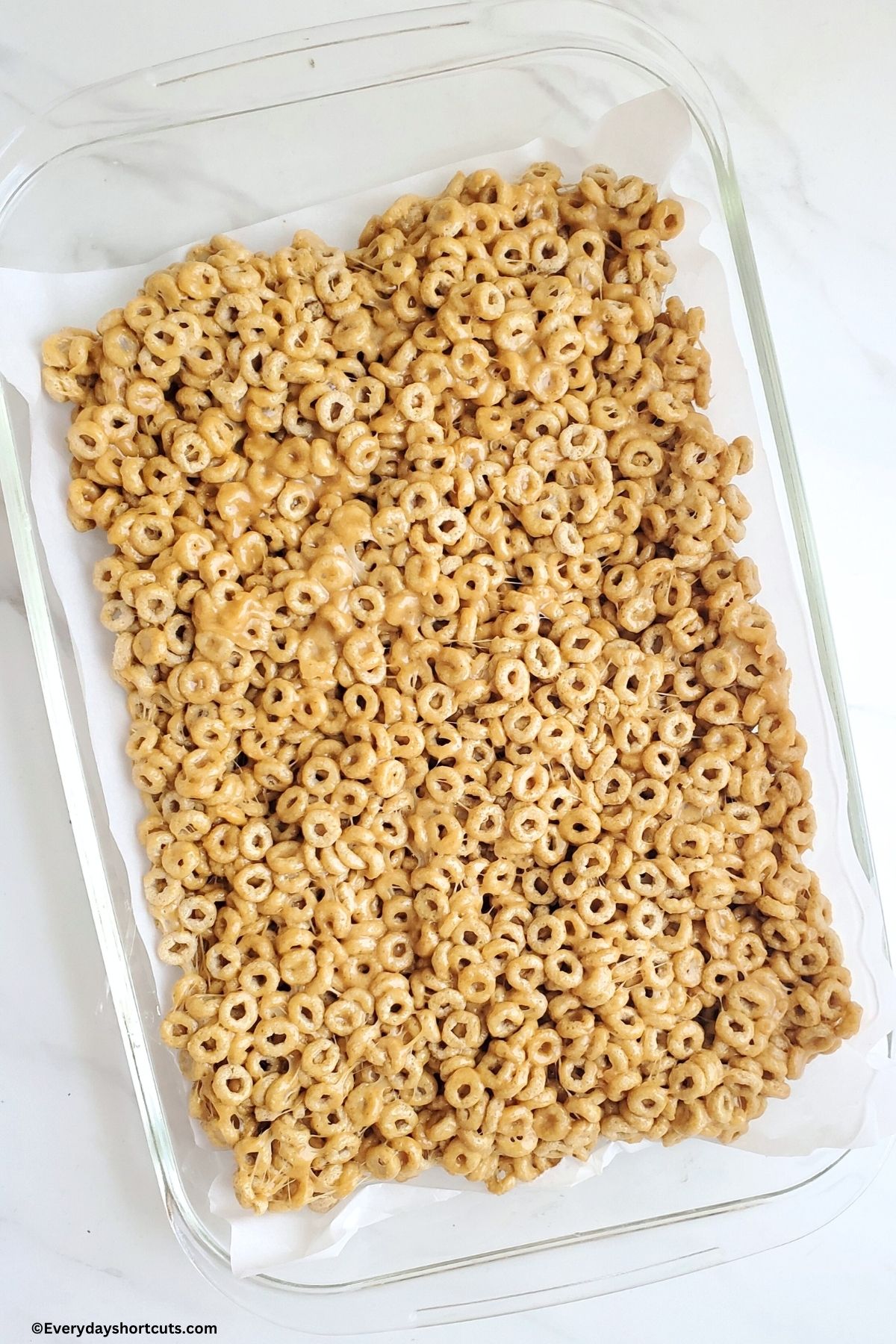 pressed Cheerios with melted marshmallow and peanut butter in a pan