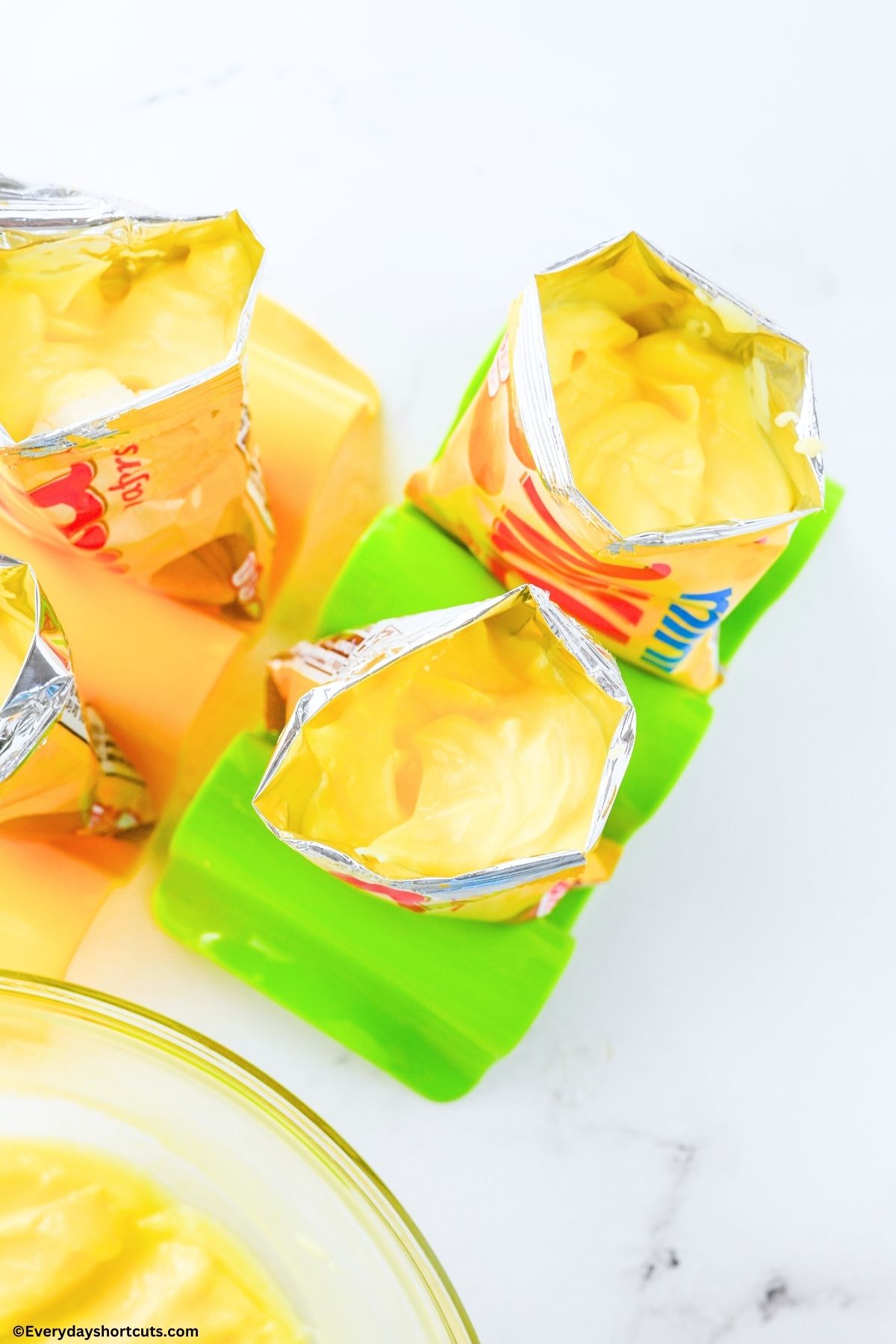 vanilla pudding mix on top of bananas and Nilla wafers in bags held on a green taco stand