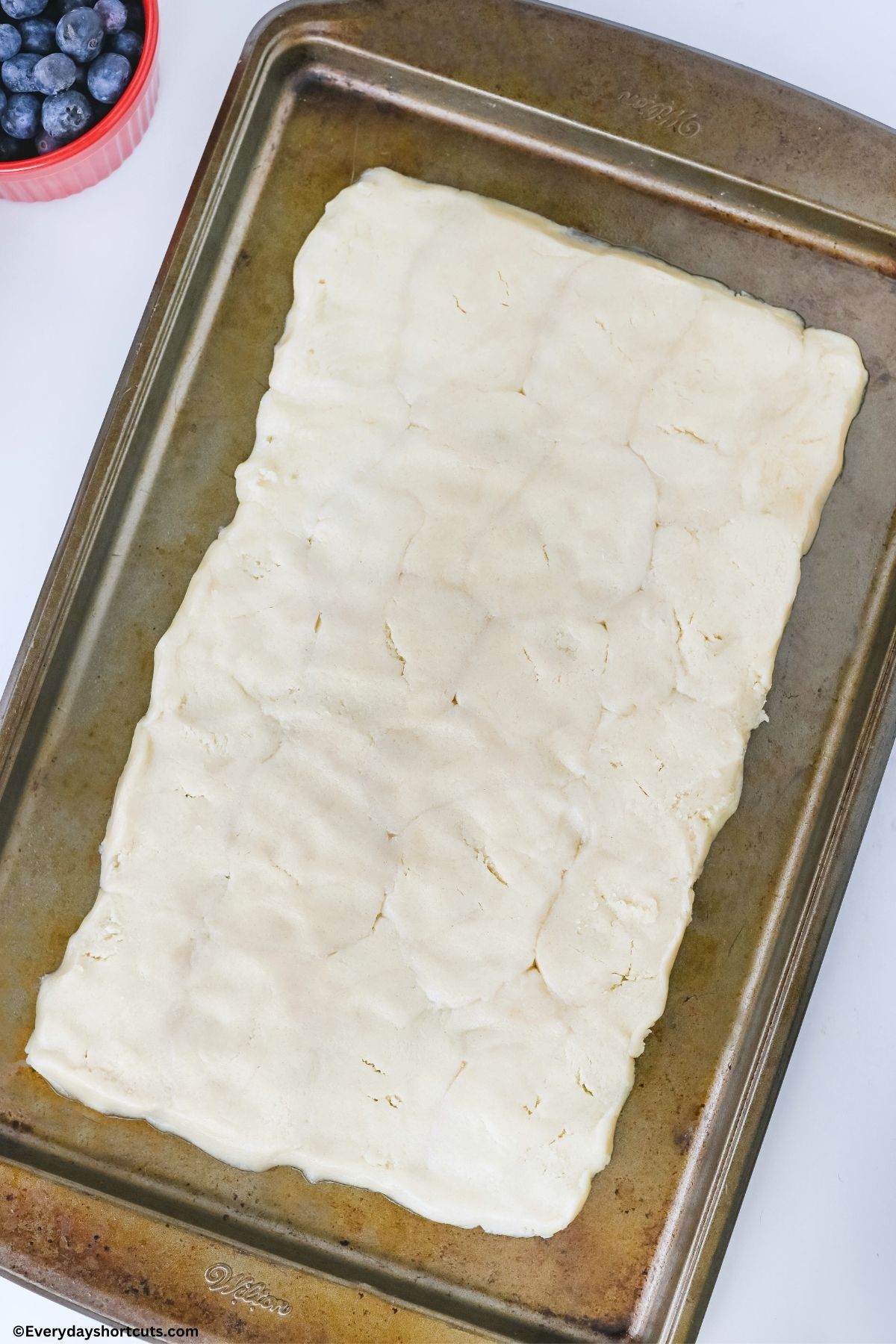 pressed sugar cookie dough on a cookie sheet