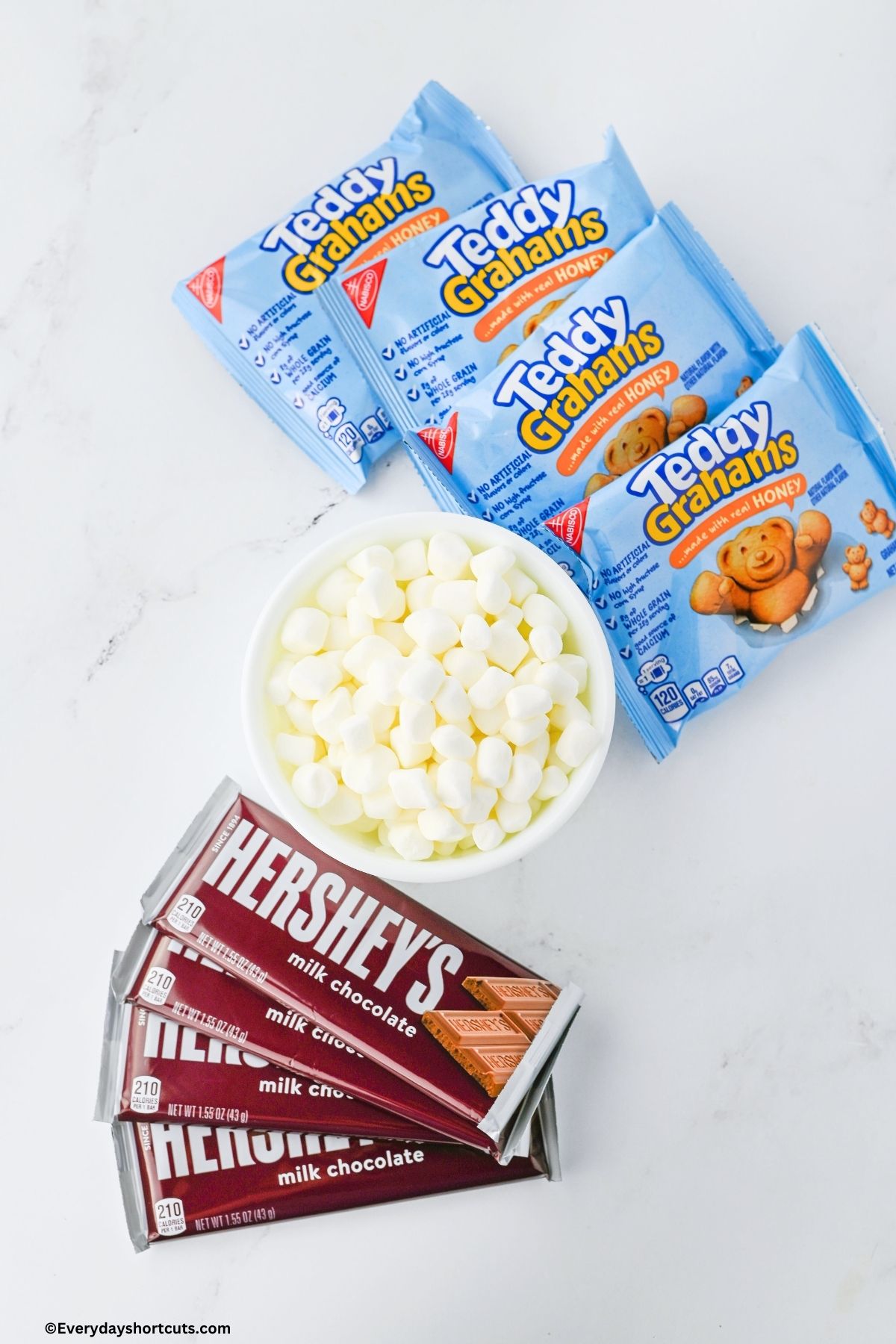 Teddy Grahams snack packs bowl of mini marshmallows and Hershey Chocolate bars on a white board