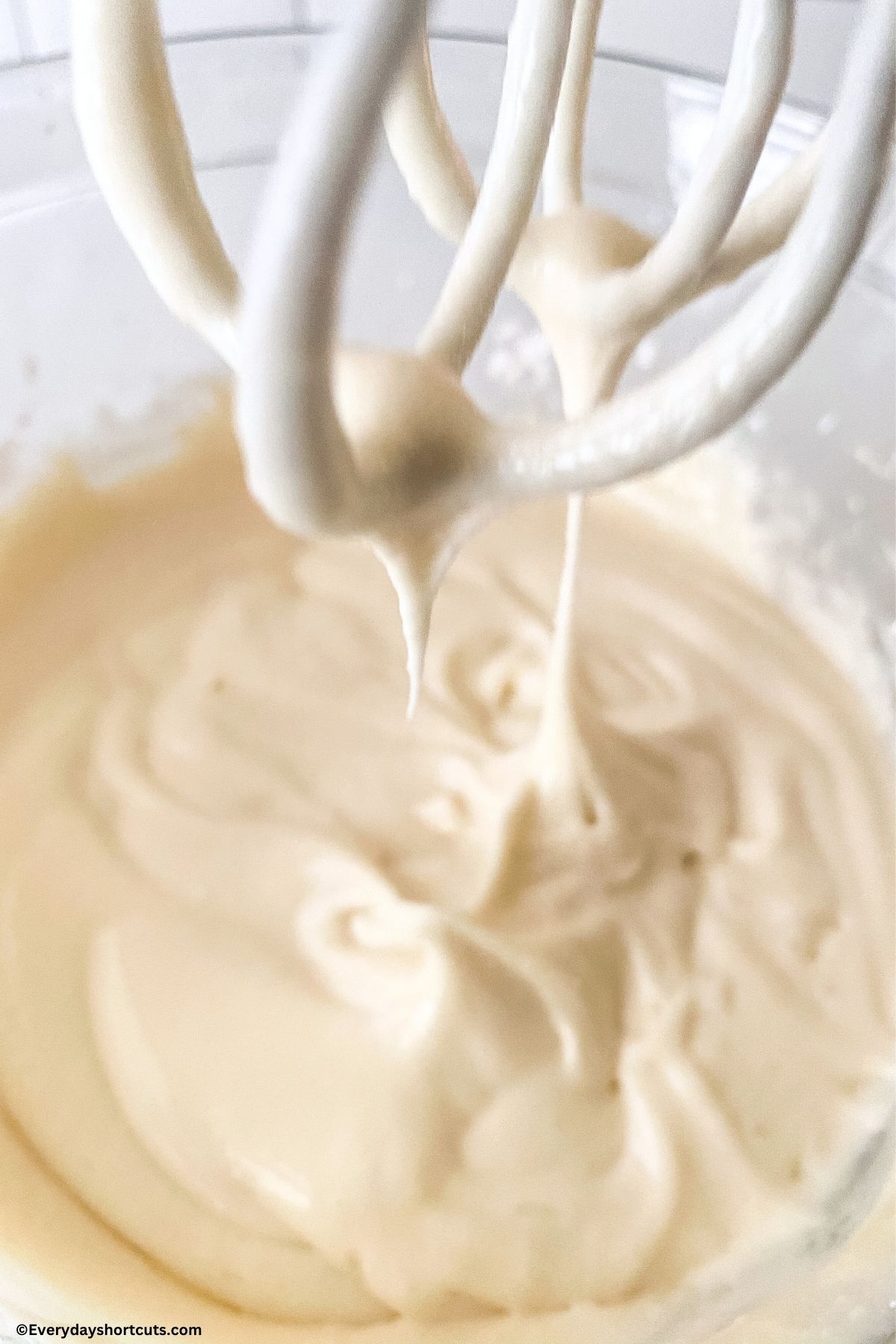 whipped cream cheese frosting in a bowl and on beaters