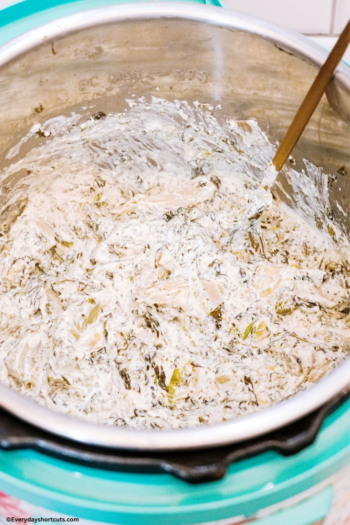 shredded cheese mixed in with spinach artichoke dip in an instant pot
