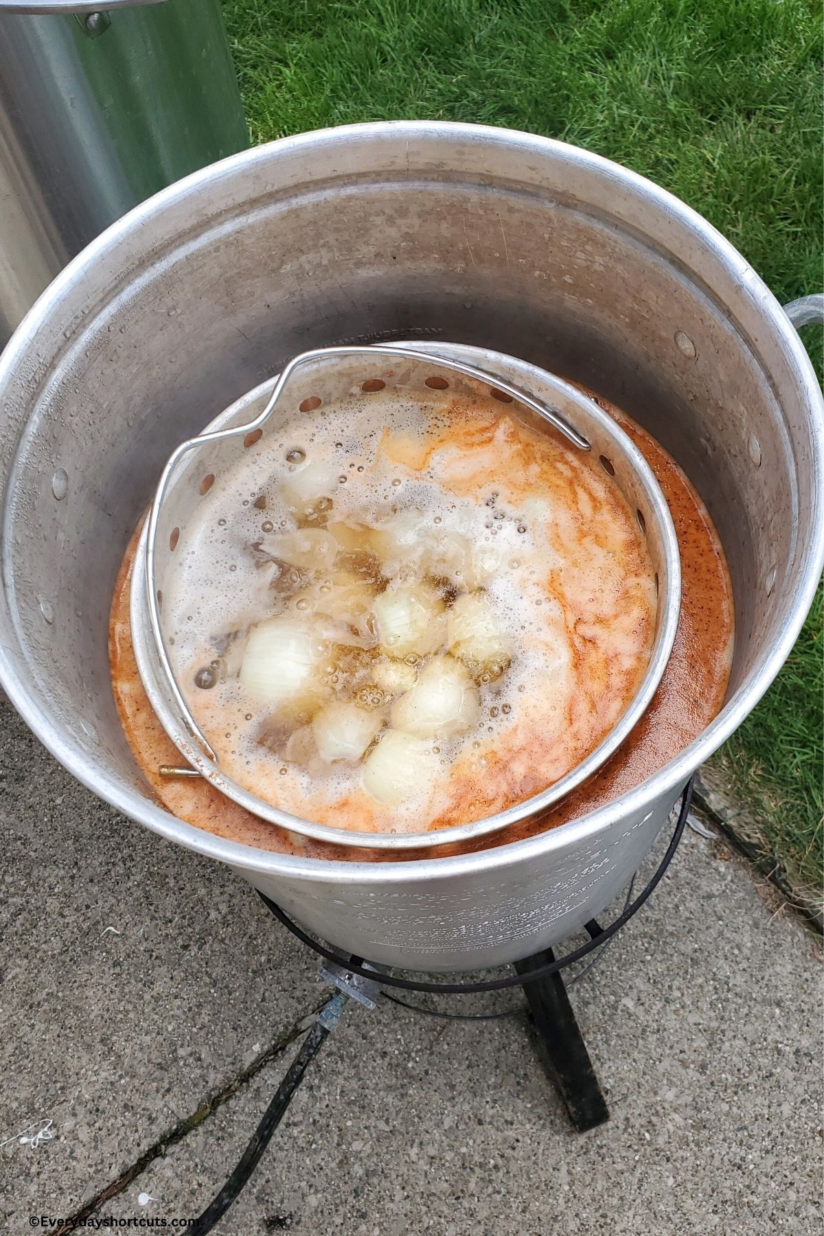 potatoes and onions boiling in a stock pot on an outdoor burner