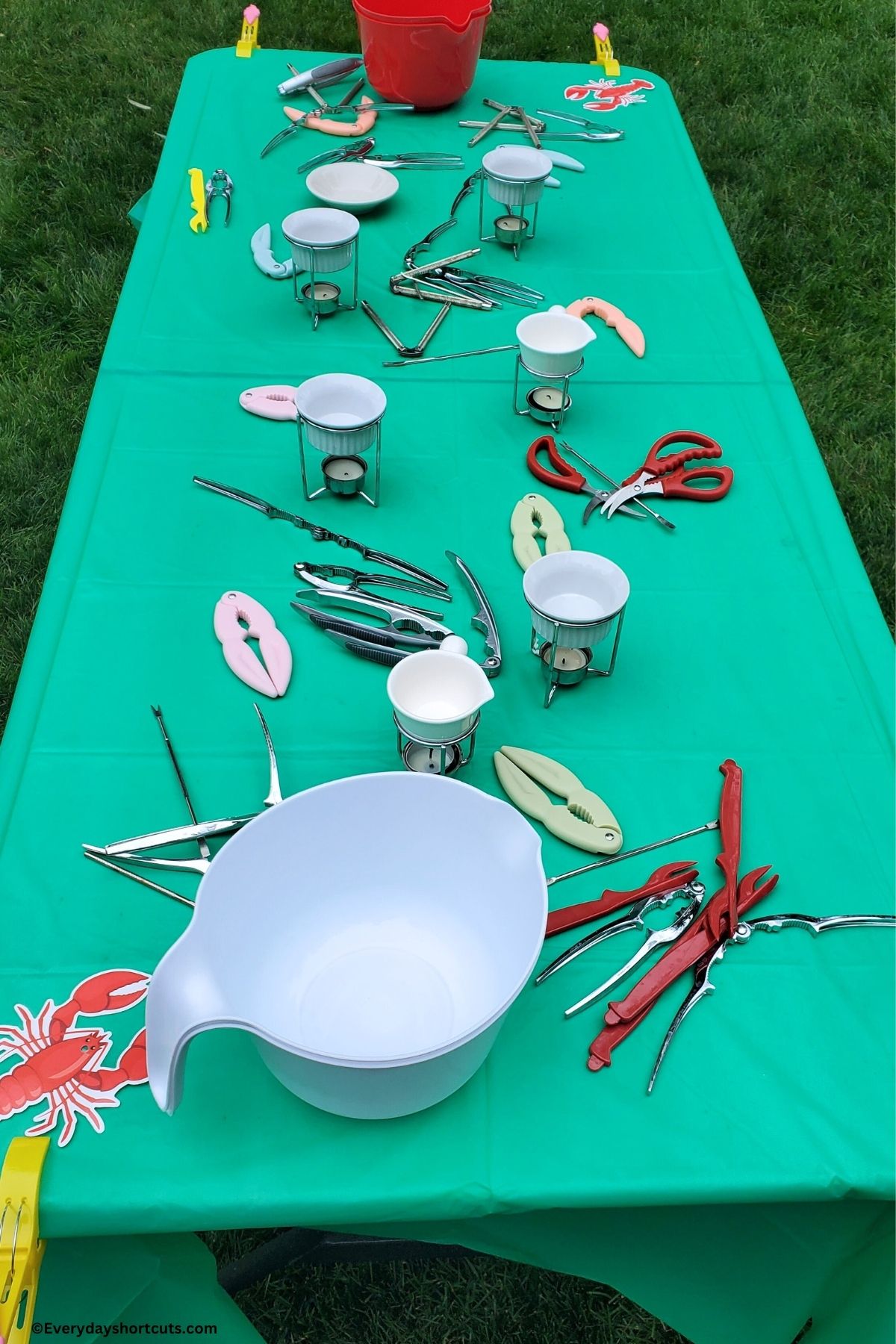 table with green table cloth with butter dishes and seafood crackers