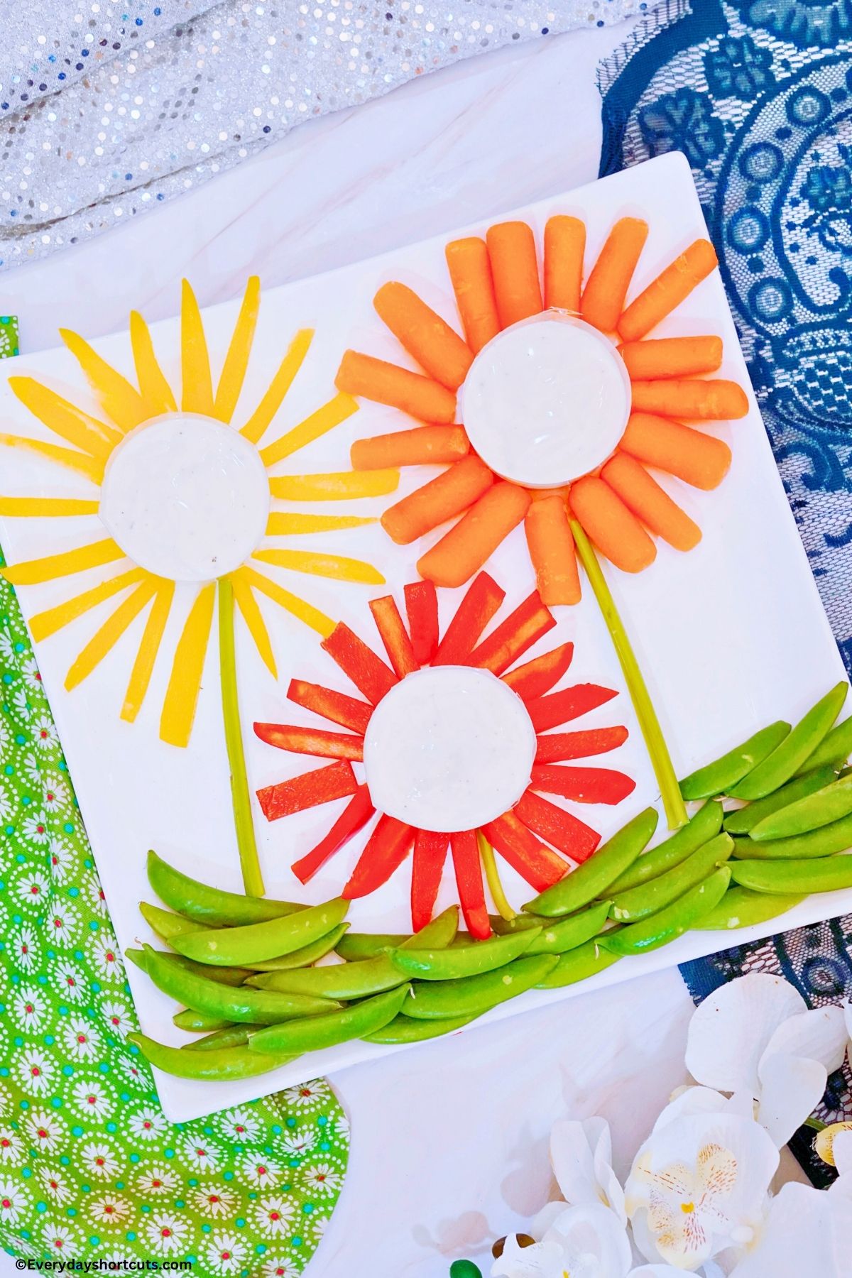 veggie flowers with ranch dressing on a white platter