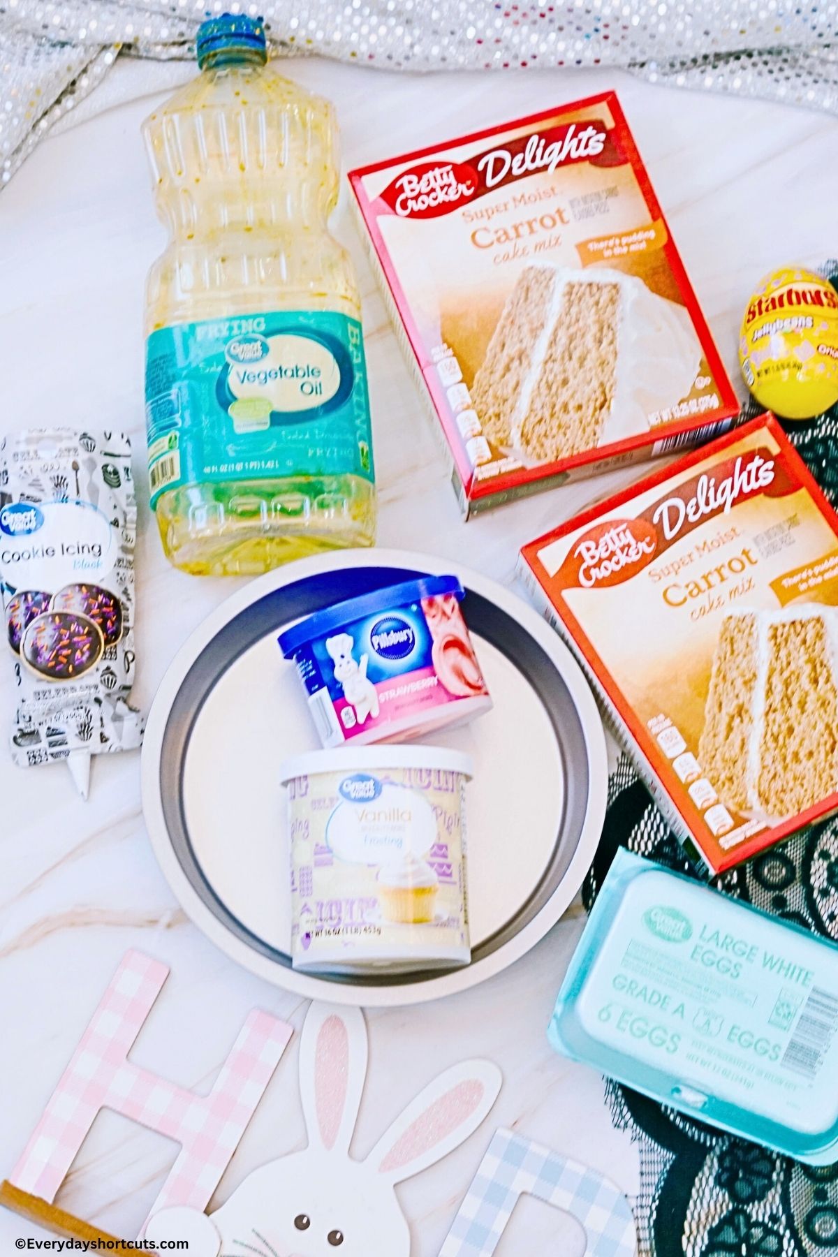 Ingredients - carrot cake mix, oil, black icing, jelly beans, pink frosting, vanilla frosting, eggs and 2 round pans
