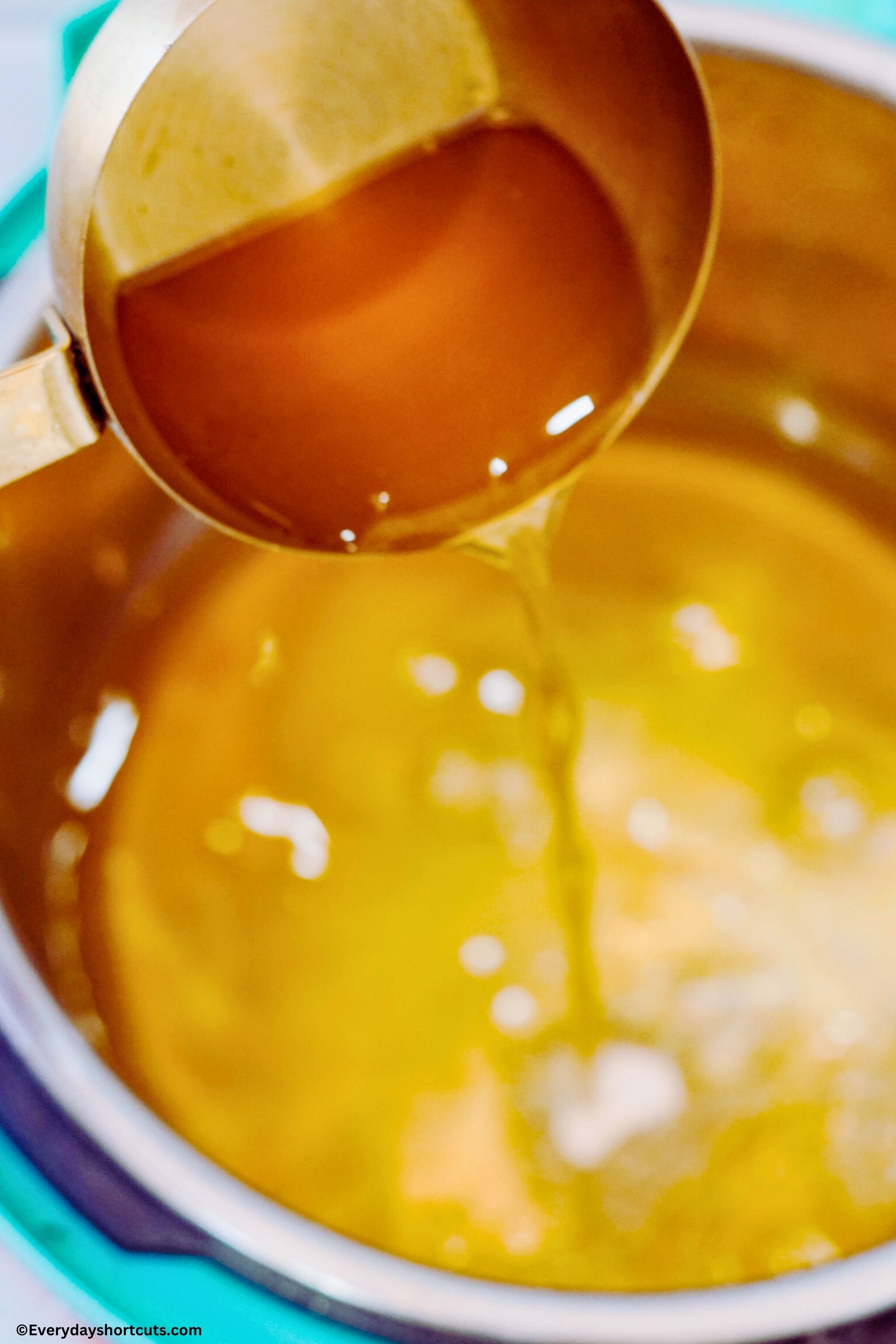 pour beef broth out of a measuring cup into an Instant Pot