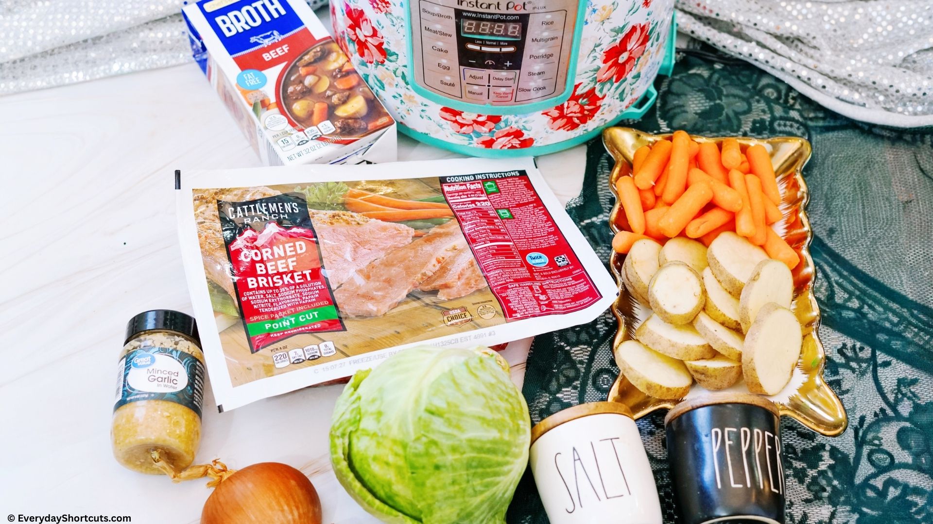 beef broth corned beef brisket carrot sliced potatoes cabbage onion minced garlic salt and pepper shakers next to a flower pattern instant pot