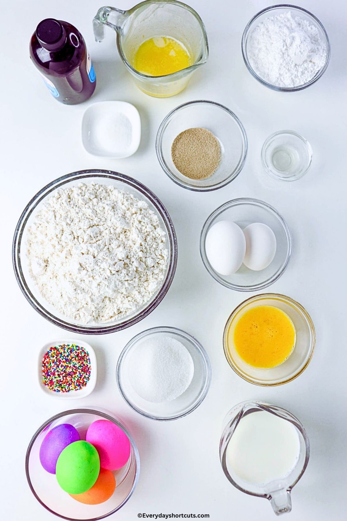 ingredients shown: milk, yeast, sugar, eggs, butter, colored eggs, powdered sugar, salt, vanilla extract, all-purpose flour and sprinkles