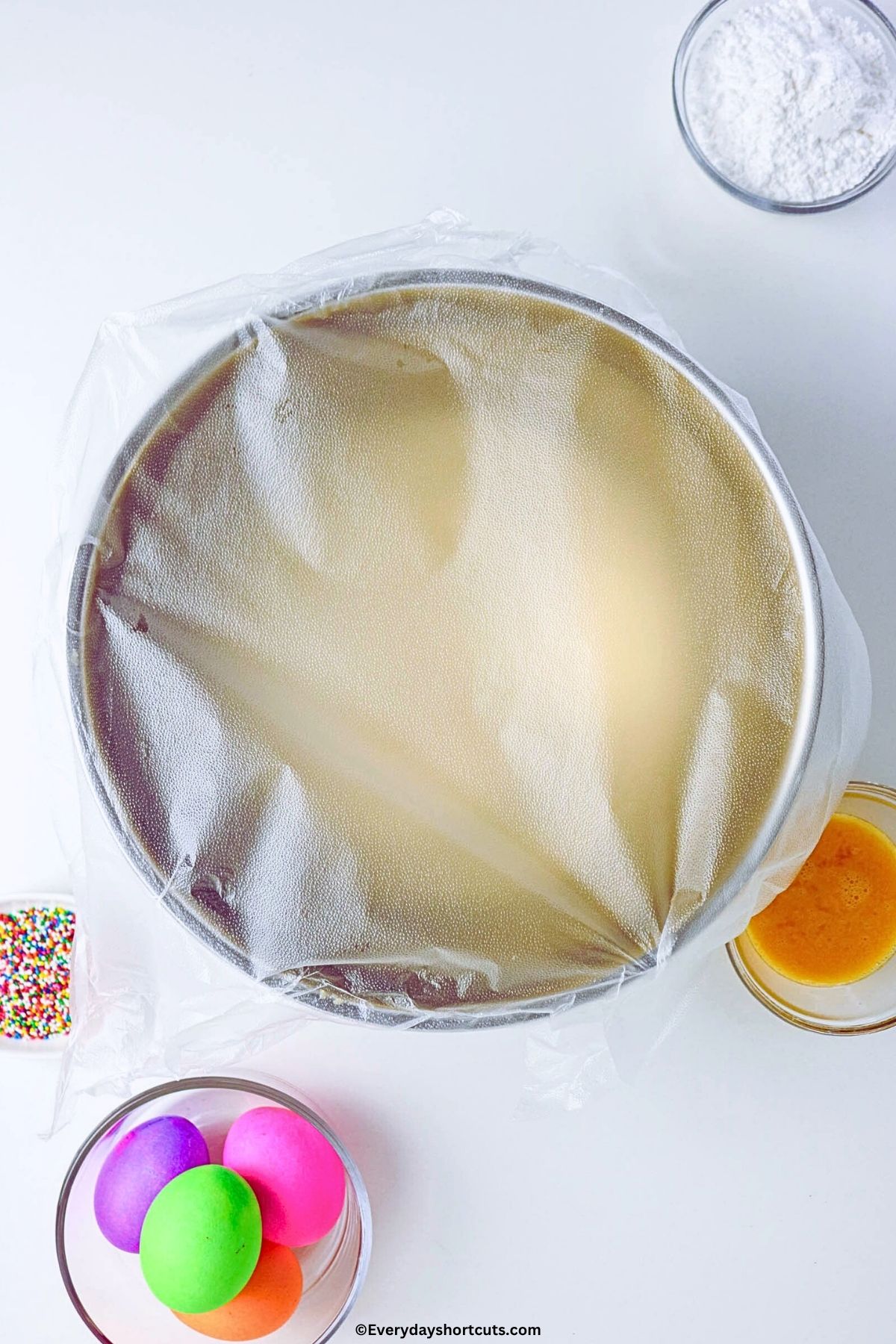 bread dough covered in plastic to rise in a kitchen aid mixer bowl