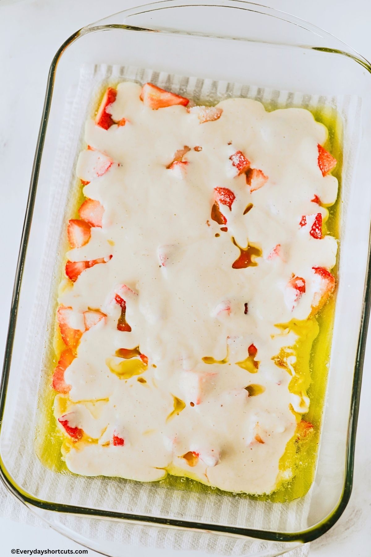 cobbler batter over top strawberries and melted butter