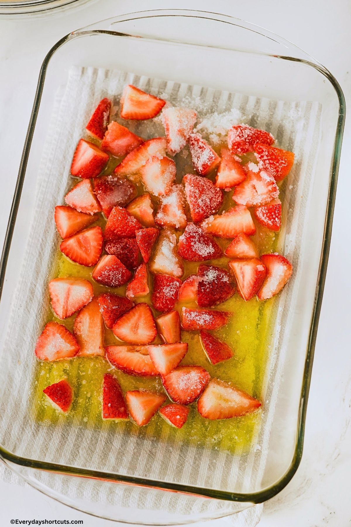 melted butter and sugar strawberries in a baking dish
