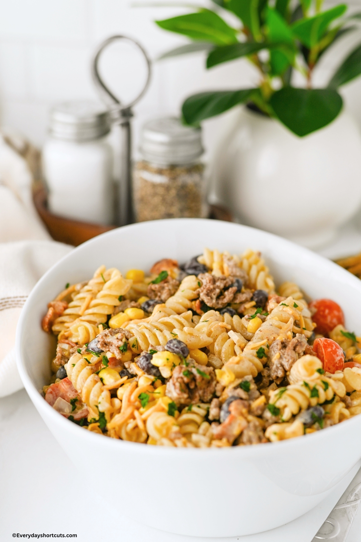 side view of cowboy pasta salad in a white bowl