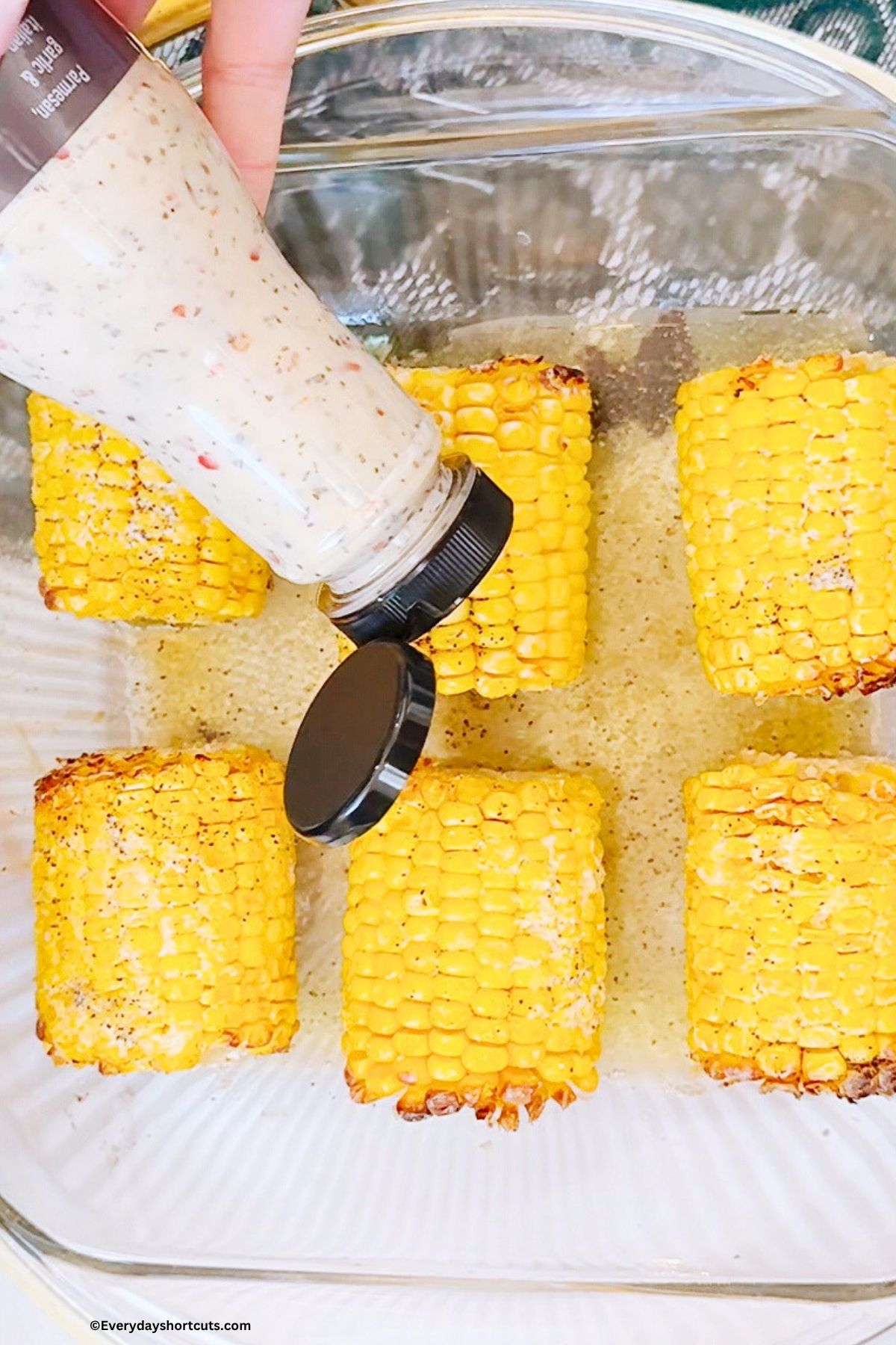 apply garlic parmesan sauce on top of corn on the cob