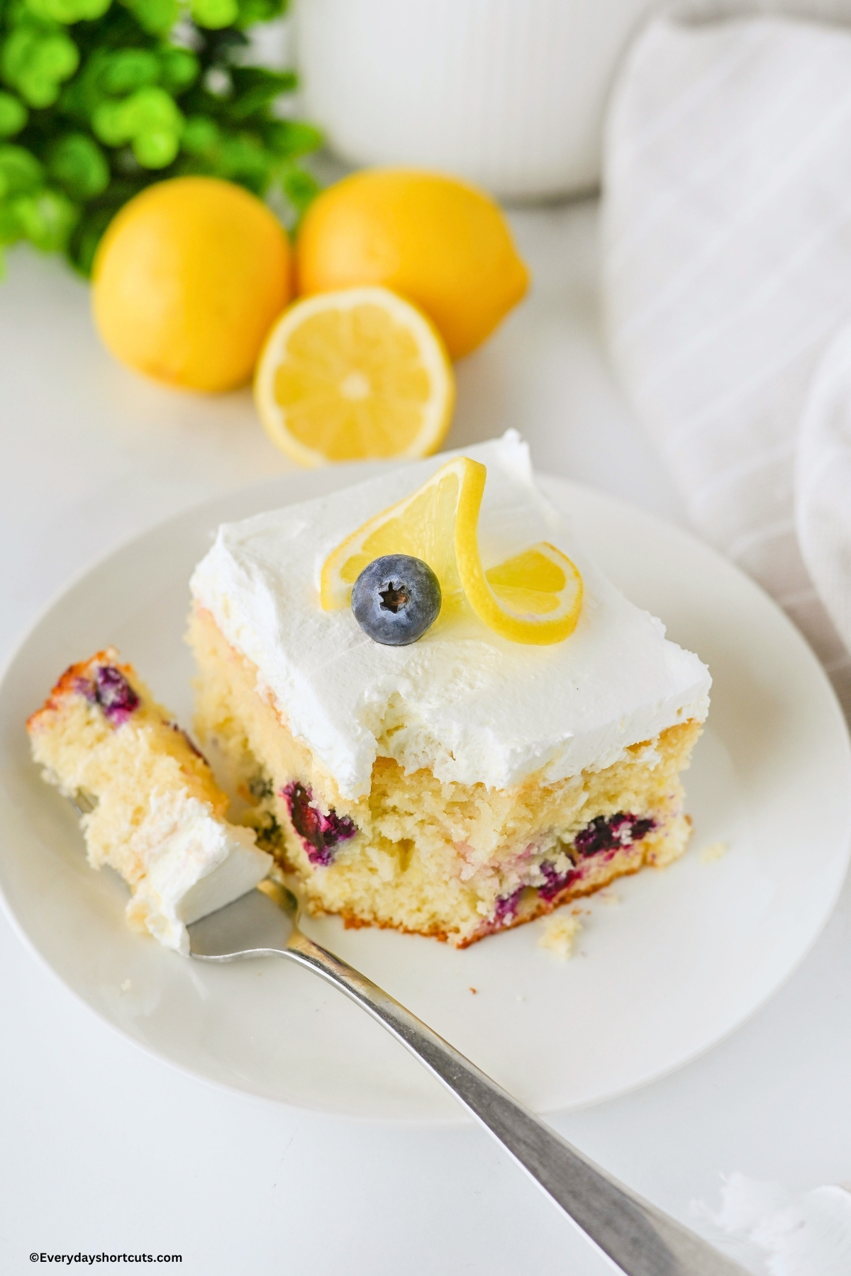 piece of cake with lemon and blueberries on a fork