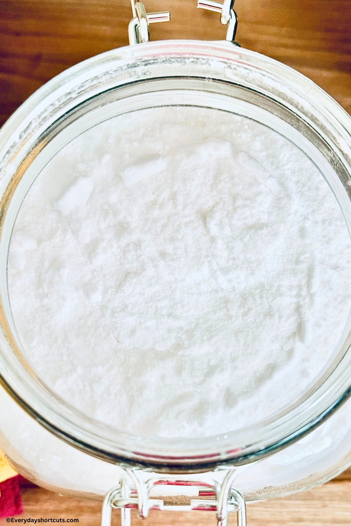 over top close up of powder laundry detergent in a glass jar