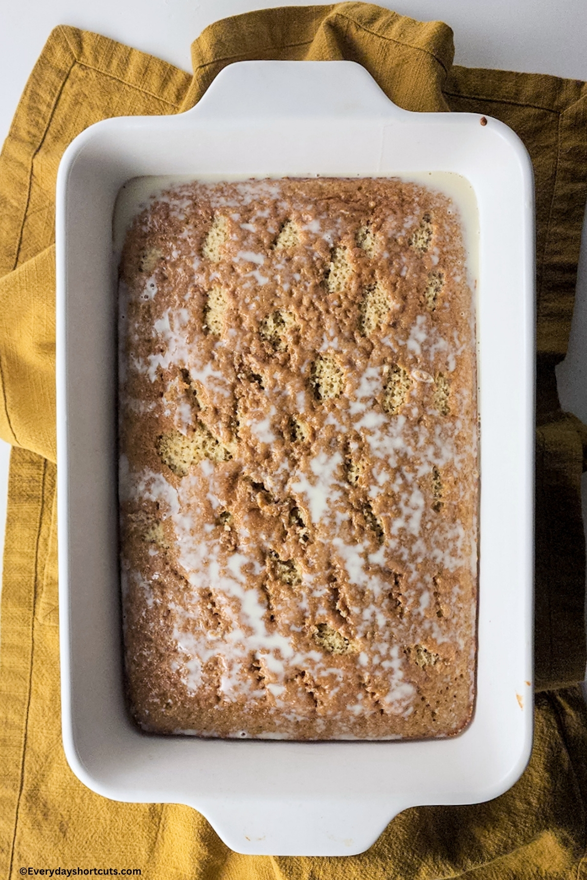 milk mixture poured over top of tres leches cake
