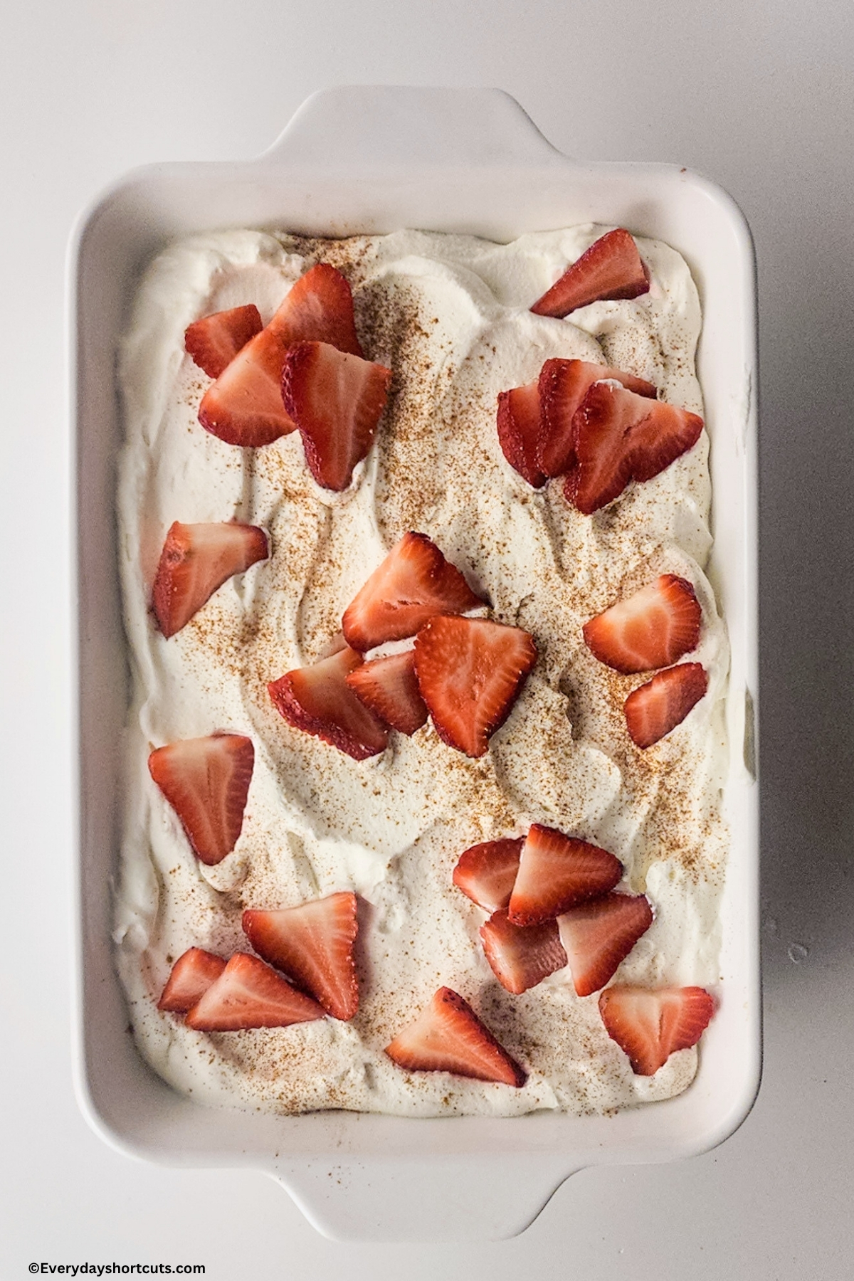a tres leches cake garnished with strawberries and cinnamon