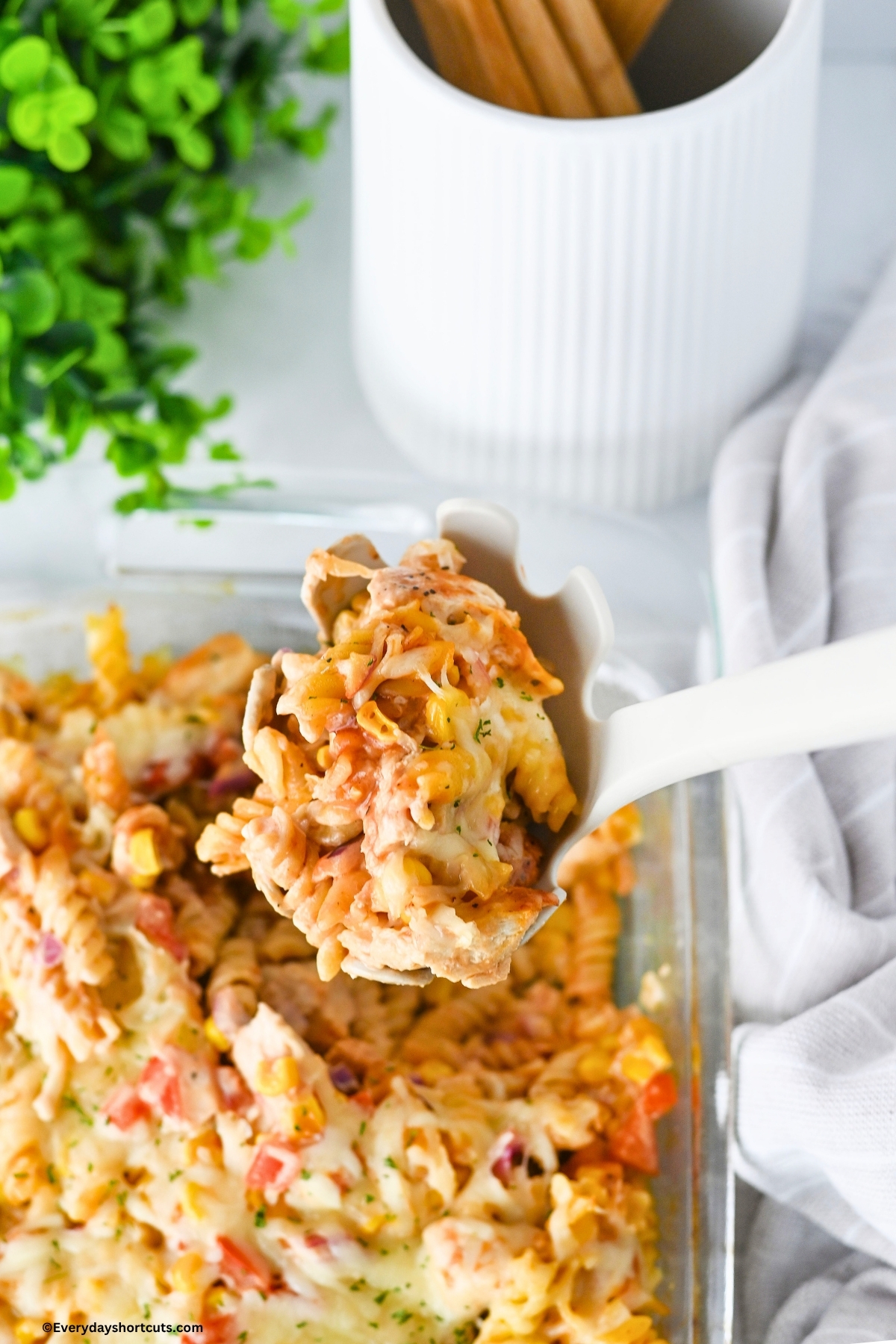 close up of BBQ ranch chicken casserole on a white ladle