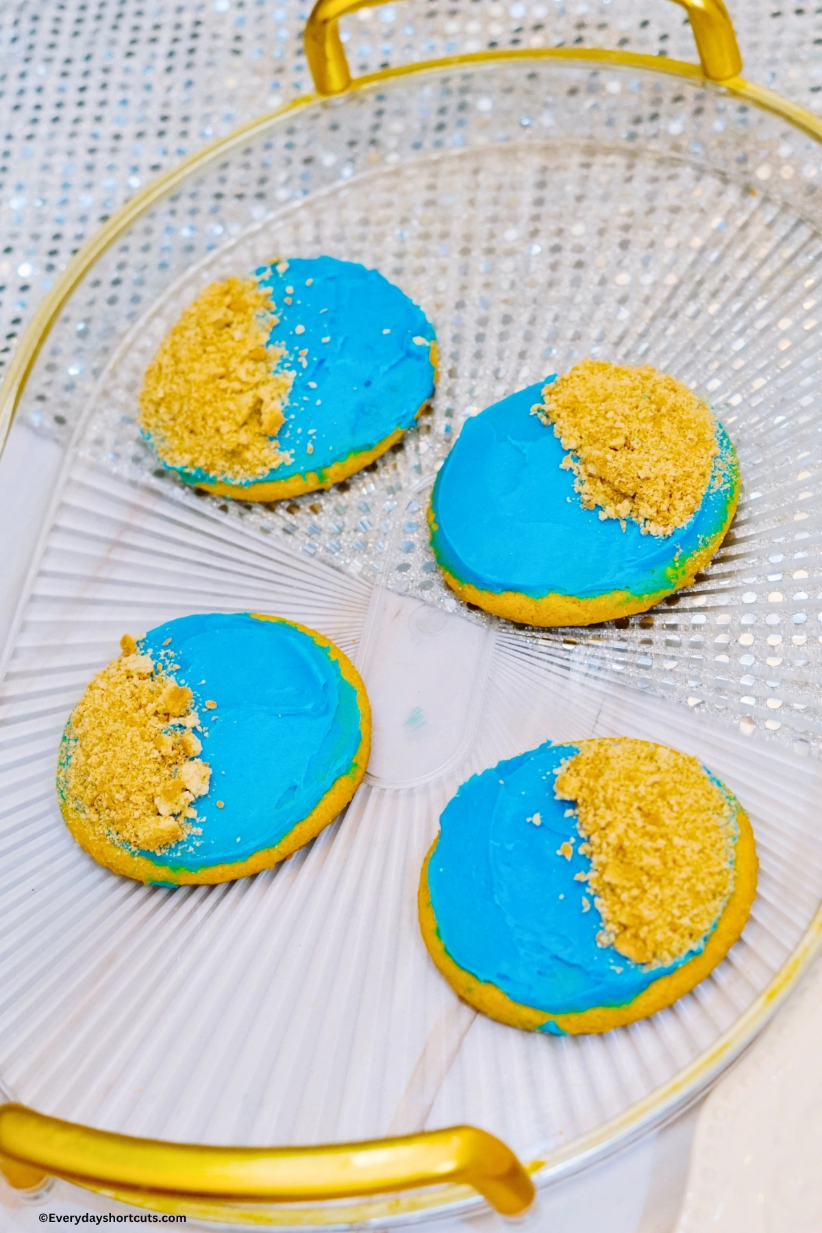 blue frosted cookies with crushed graham crackers on top