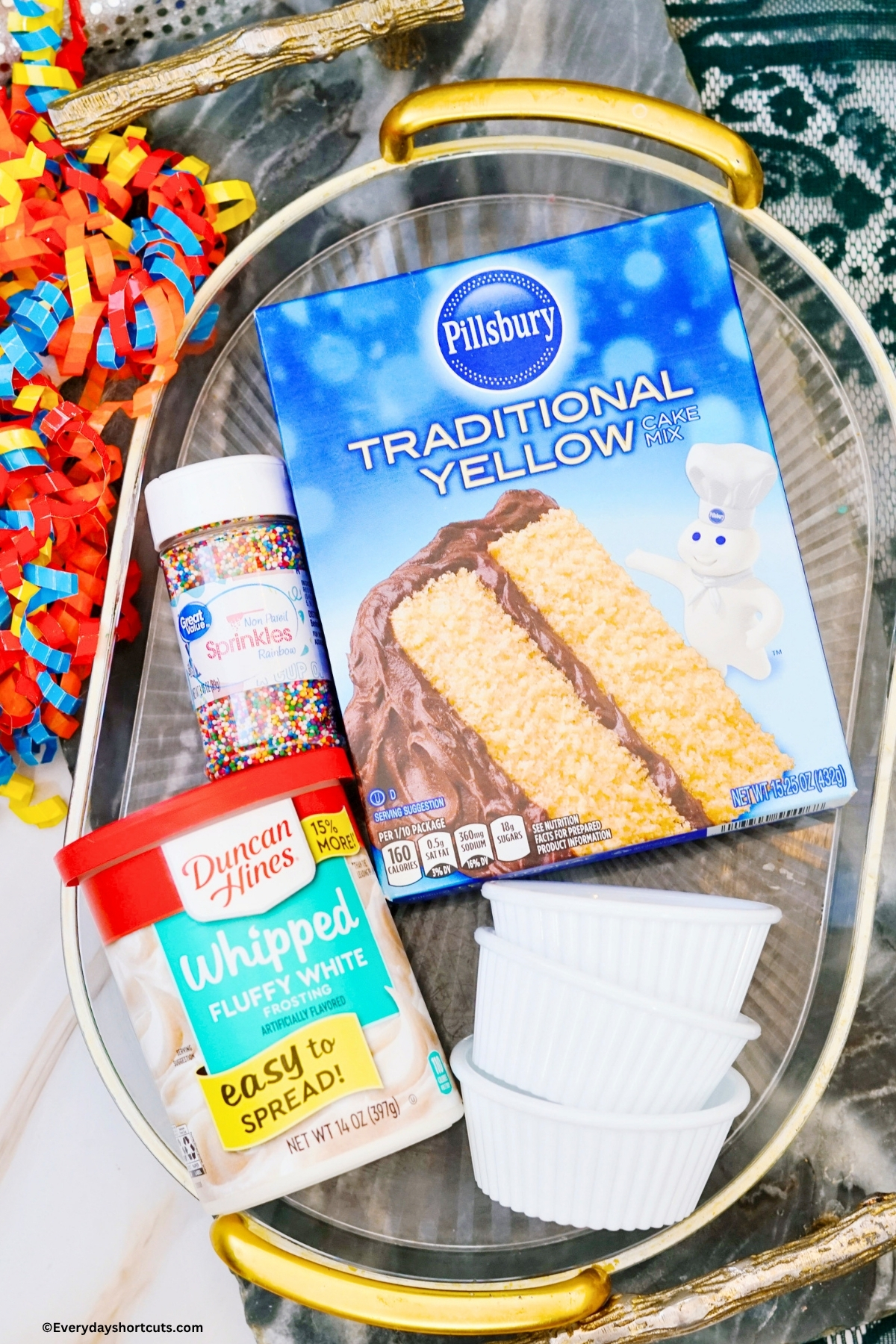 ingredients shown: yellow box cake mix, nonpareil sprinkles, white frosting and ramekin bowls