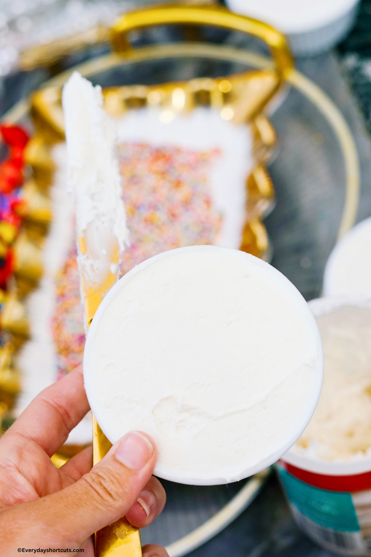 holding a frosted cake in a white ramekin bowl