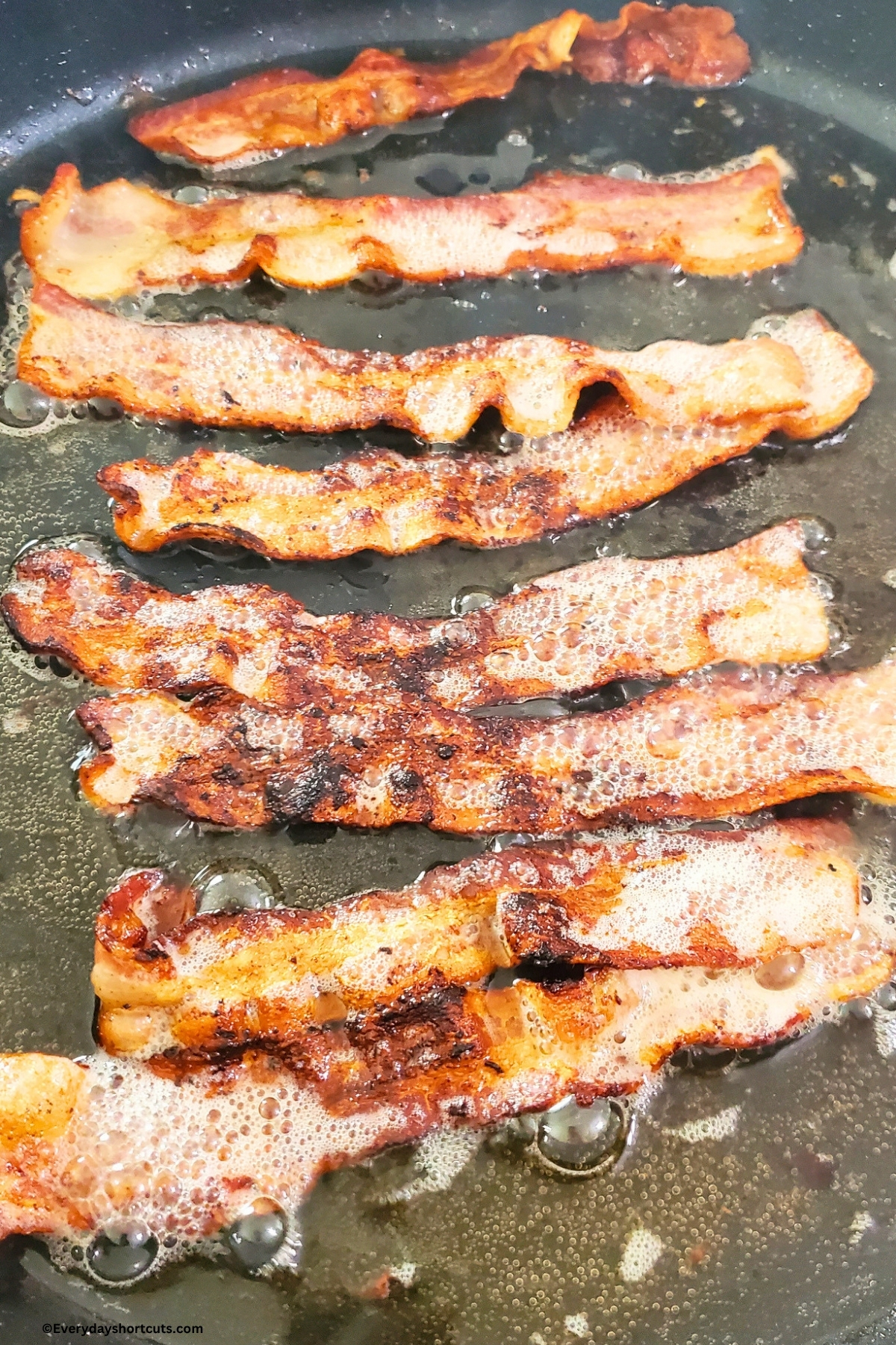 cooked bacon with bacon grease in a pan