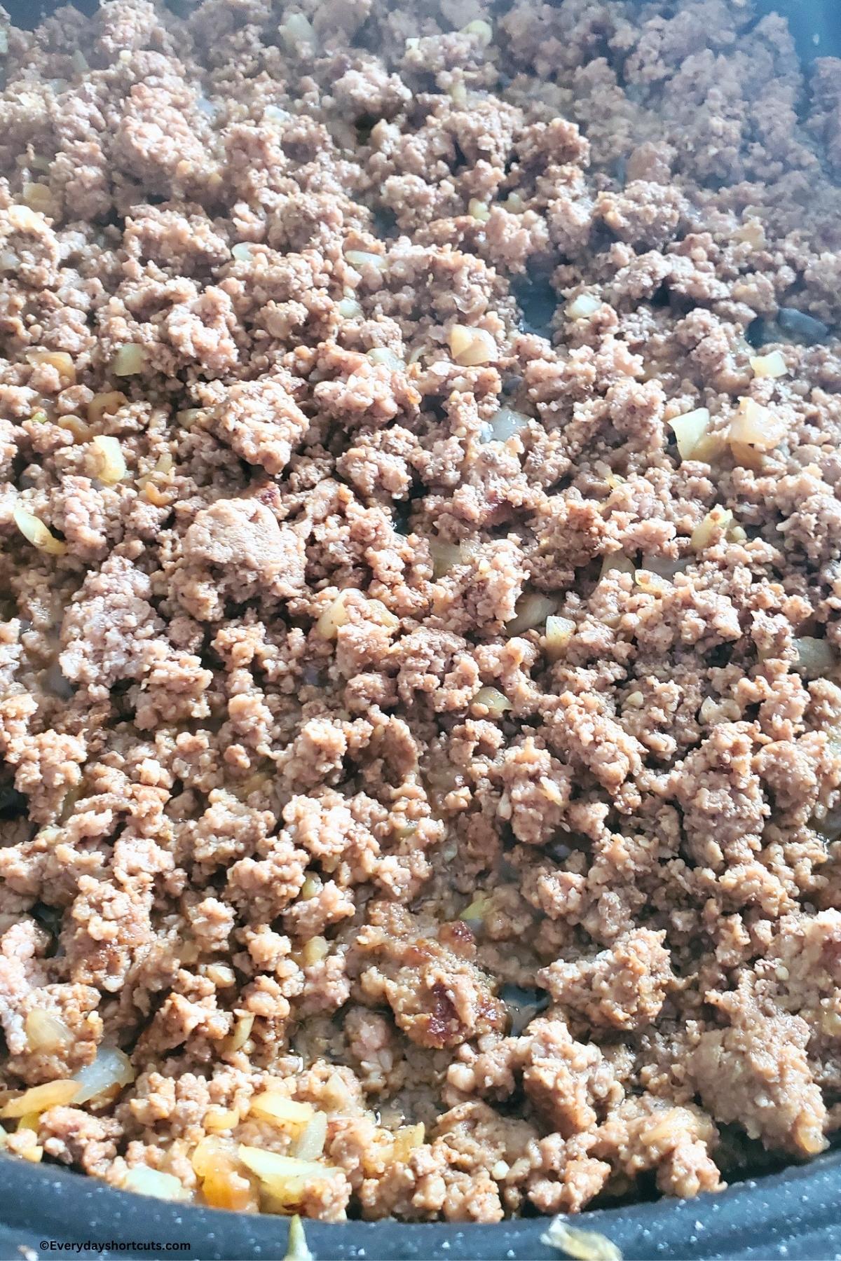 cooked ground beef and onions in skillet