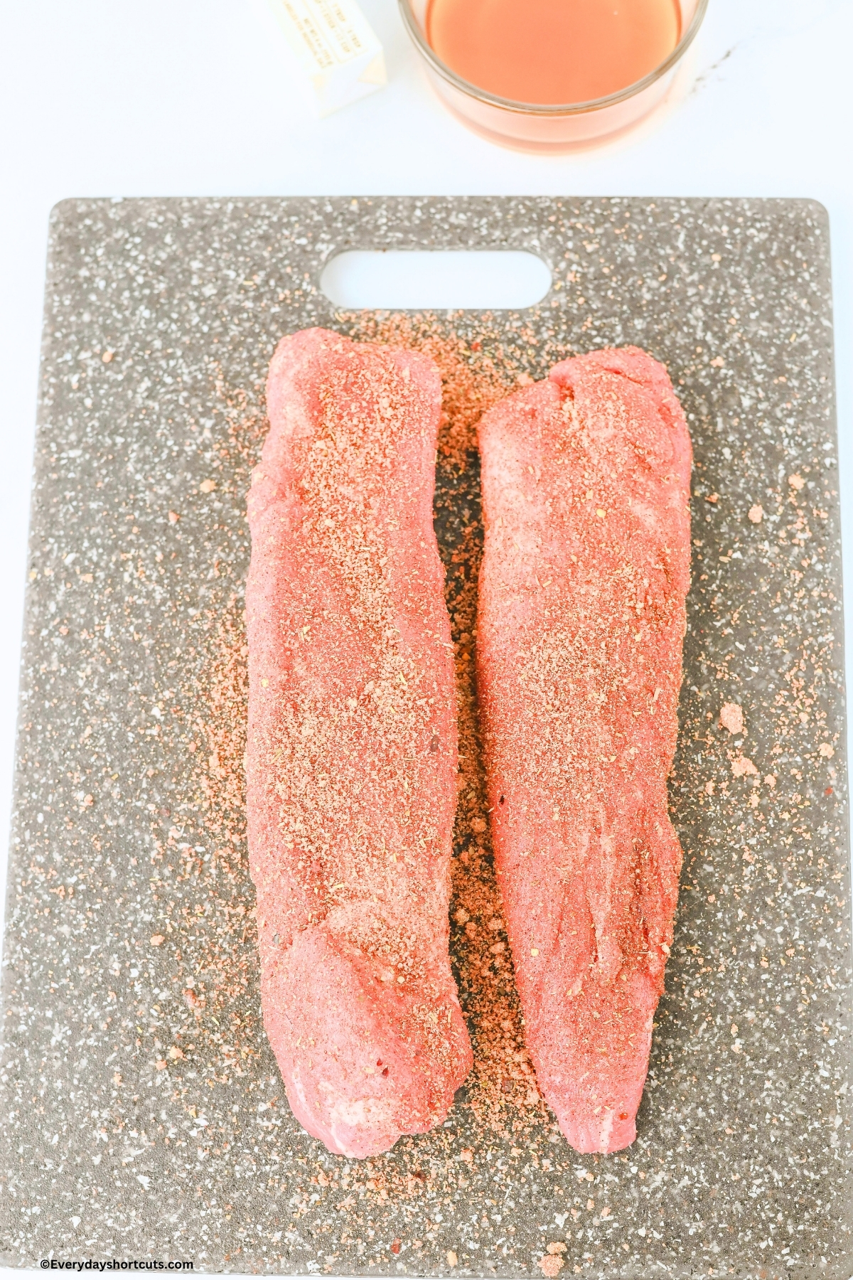 2 pork tenderloins seasoned on a cutting board