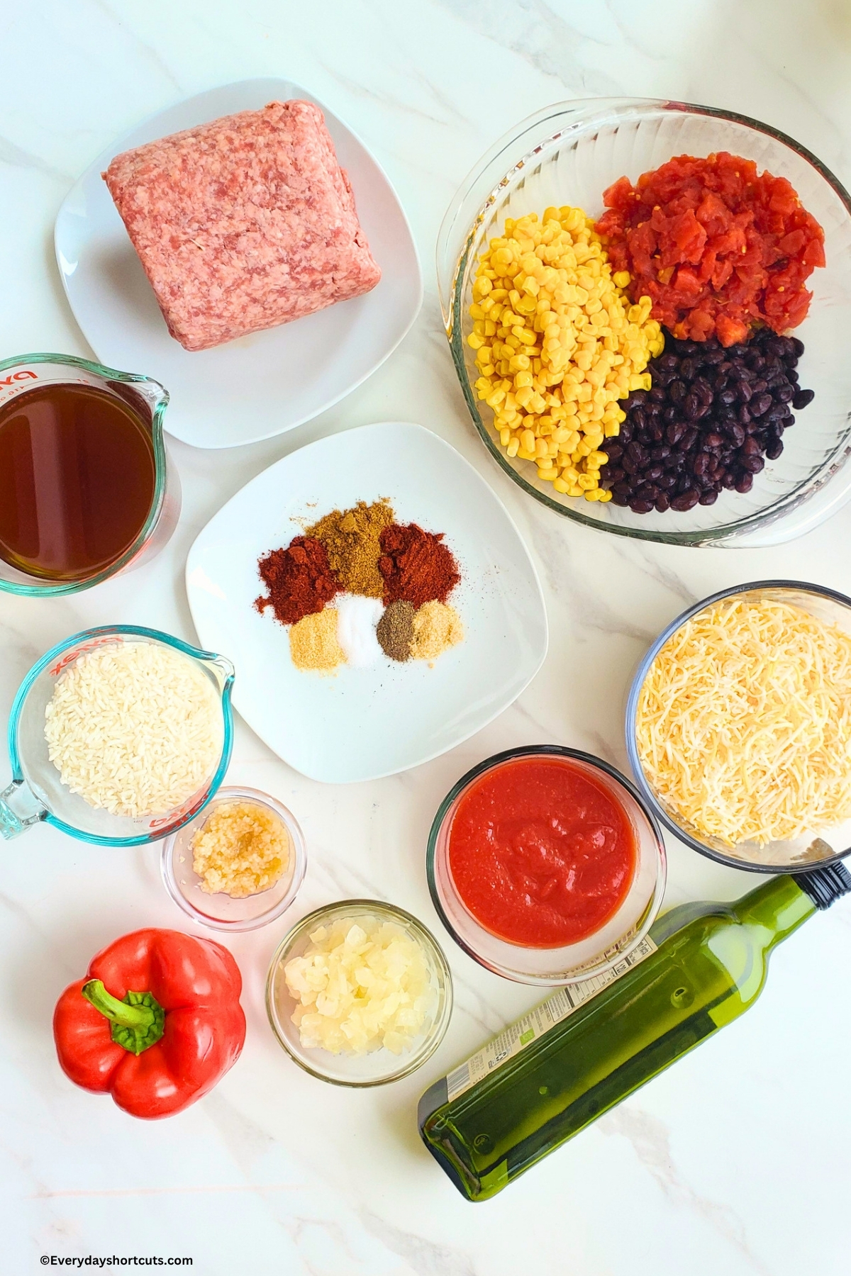 ingredients shown: ground beef, beef broth, white rice, shredded cheese, black beans, corn, rotel tomatoes, minced garlic, tomato sauce, onion, red bell pepper, olive oil, salt, pepper, cumin, paprika, chili powder, onion powder, garlic powder