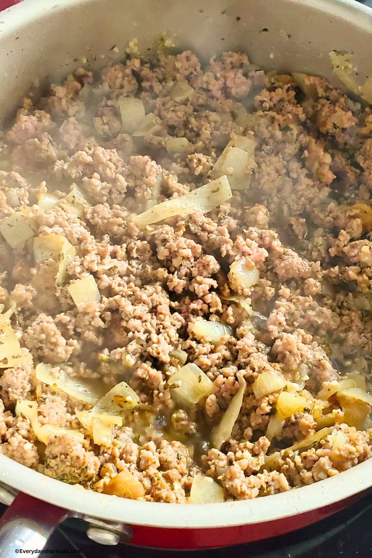 ground beef, onions and garlic cooking in a pan