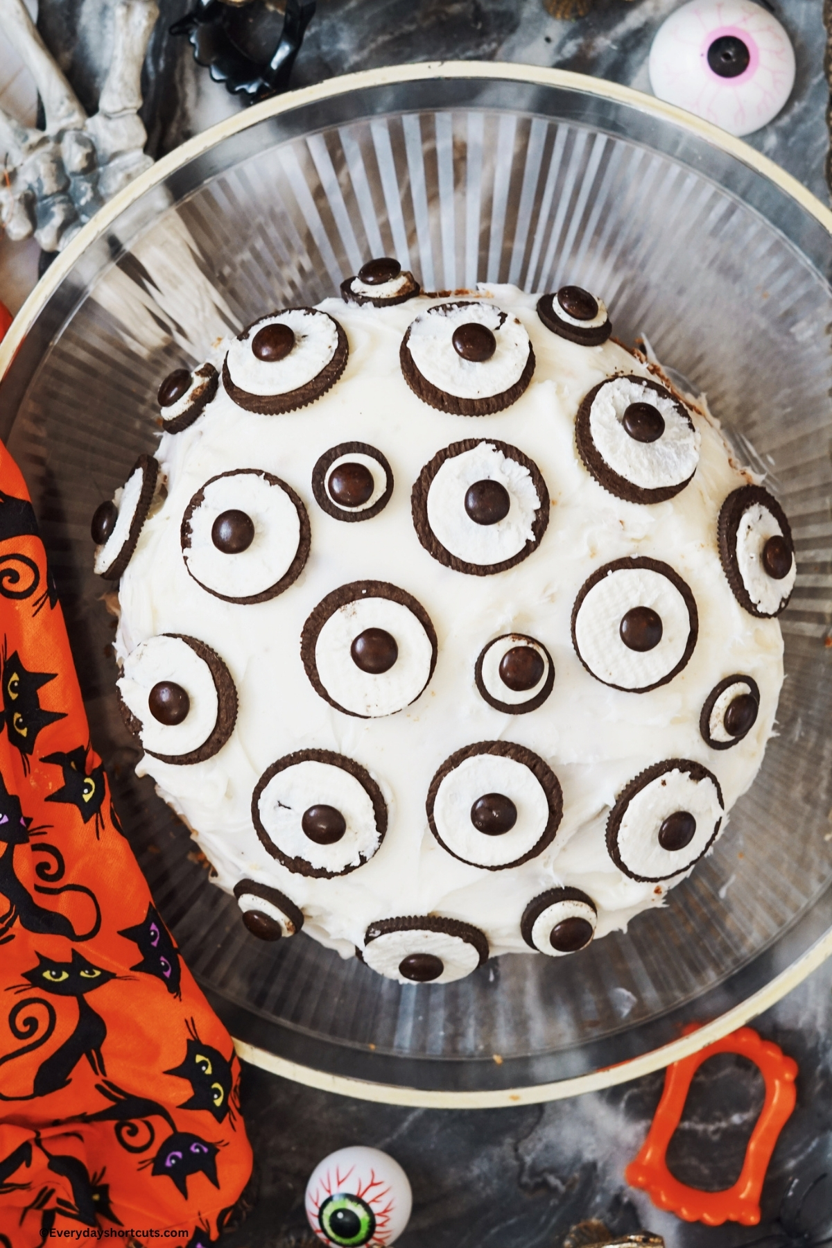 Halloween Oreo eyeball cake on a clear platter next to a black cat napkin