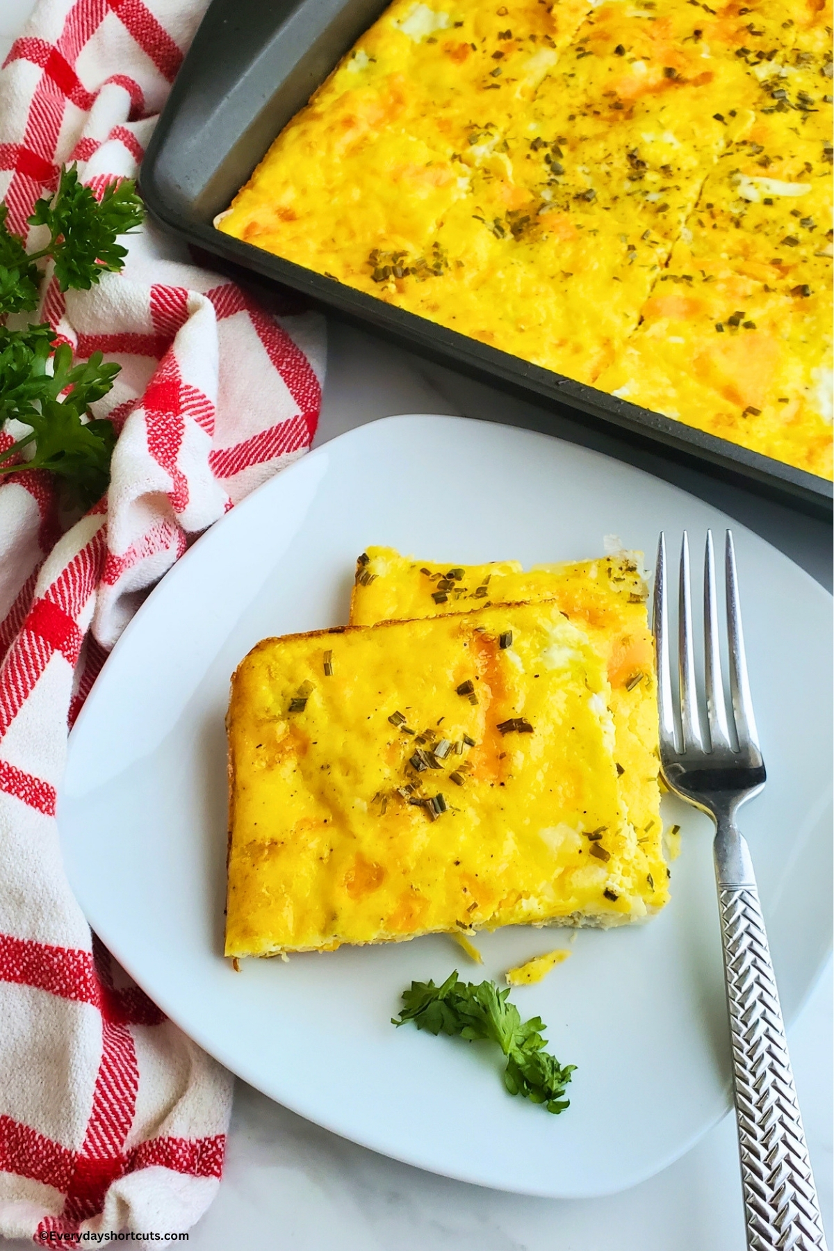 eggs cut into squares on a white plate next to a fork