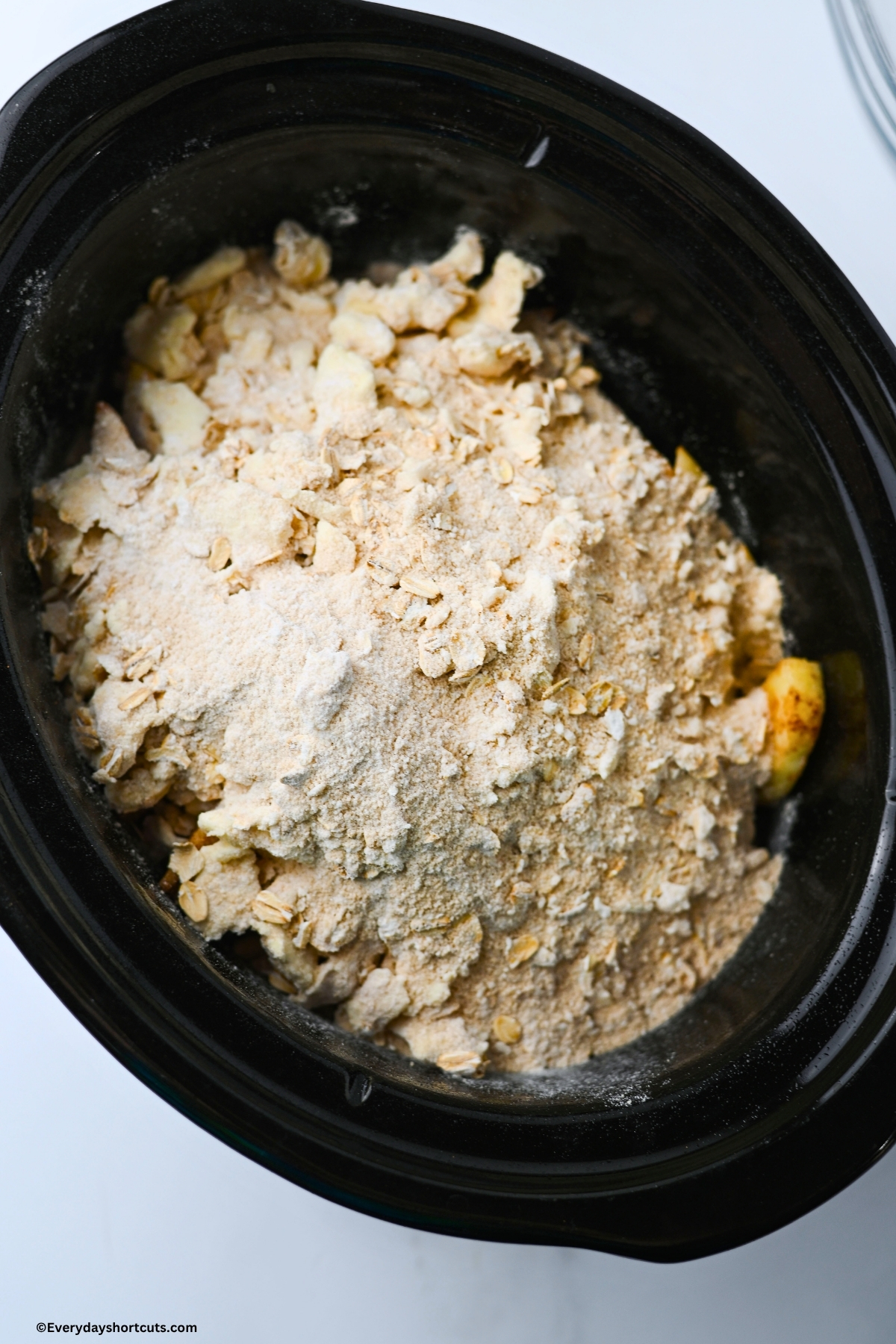 oat mixture on top of peeled and sliced apples in a crockpot
