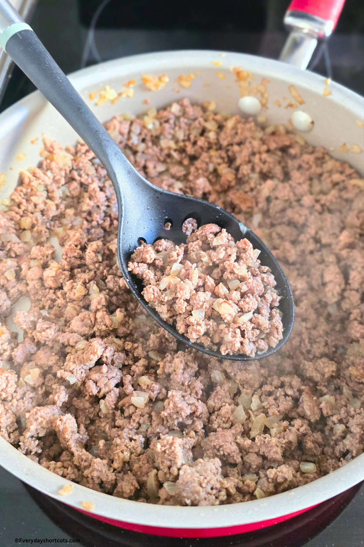 browned ground beef with onions in a pan